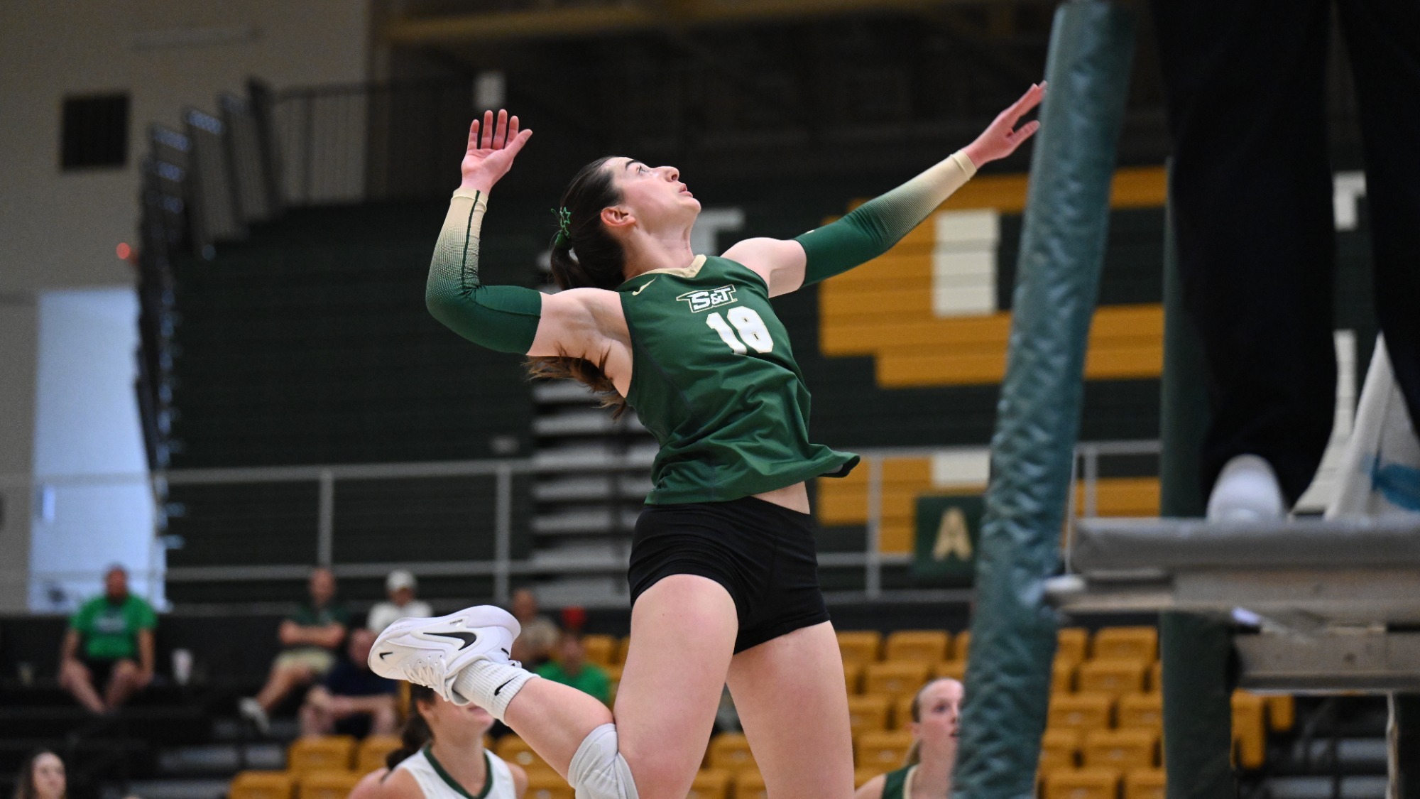 Selin Ozdemir of Missouri S&T photographed wearing a green uniform and jumping to attack a ball during a match in Gibson Arena