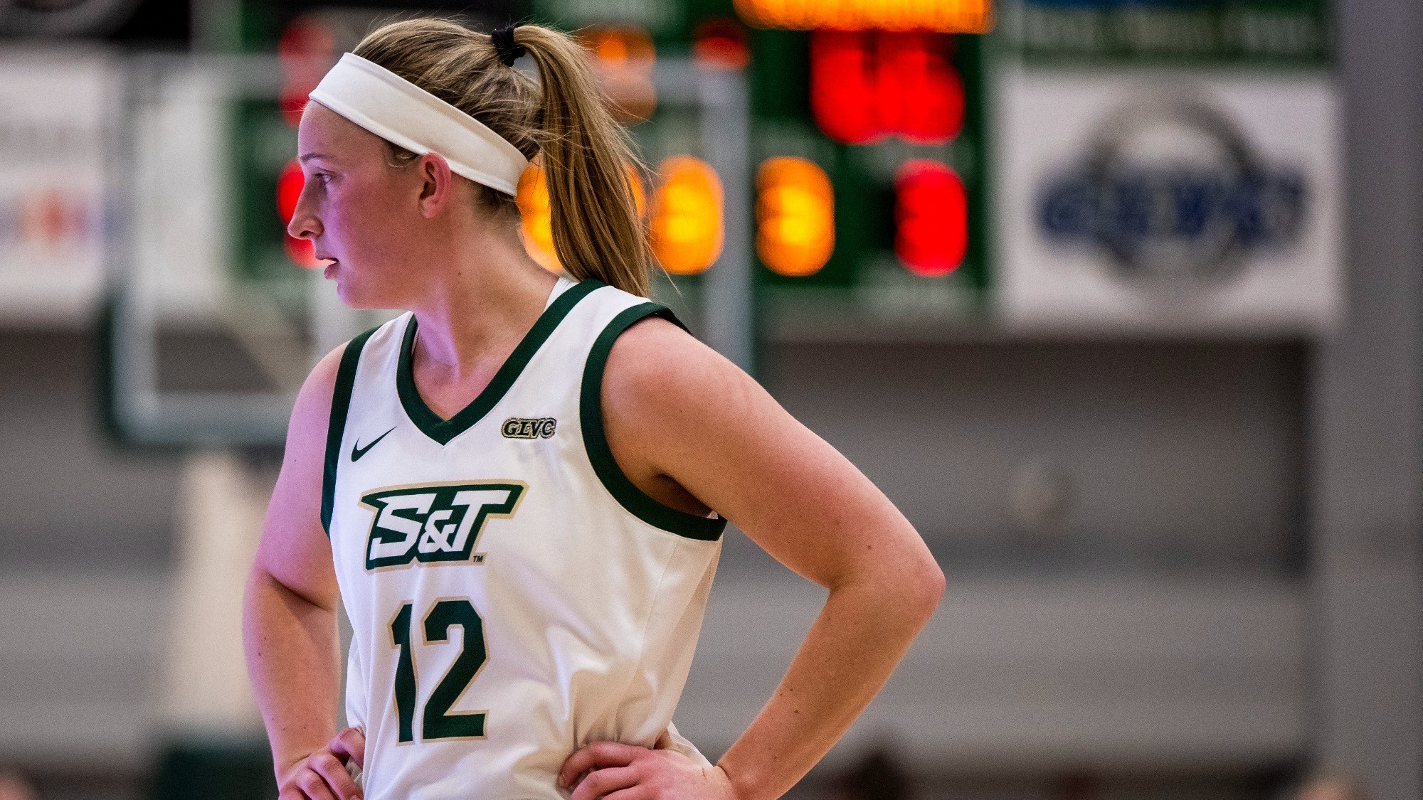 Missouri S&T women's basketball player Anna Finley stands with hands on her hips and looking to her right during a home basketball game
