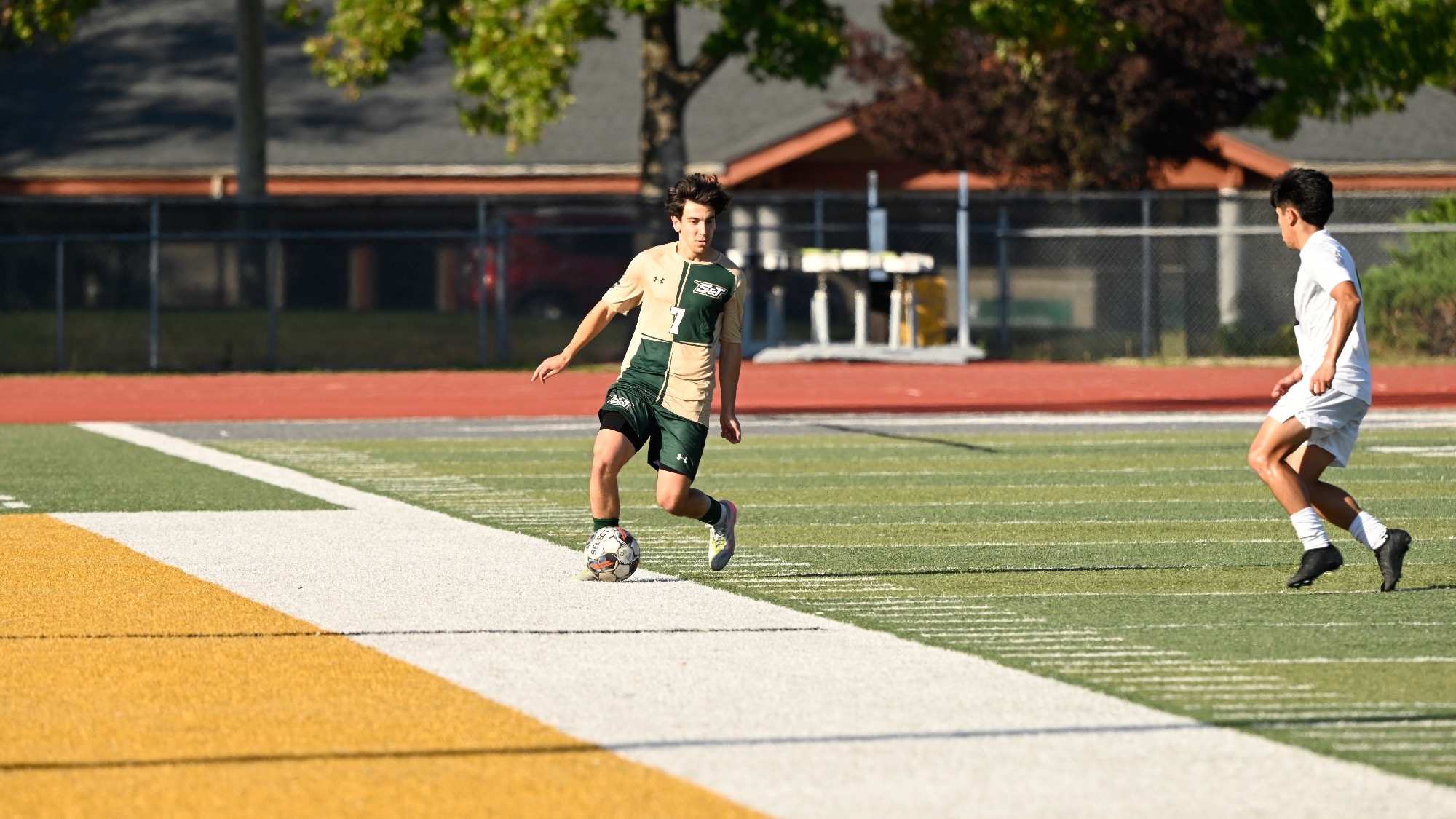 Missouri S&T midfielder Joao Vieira dribbling the soccer ball at Allgood Bailey Stadium with a defender creeping up on him.