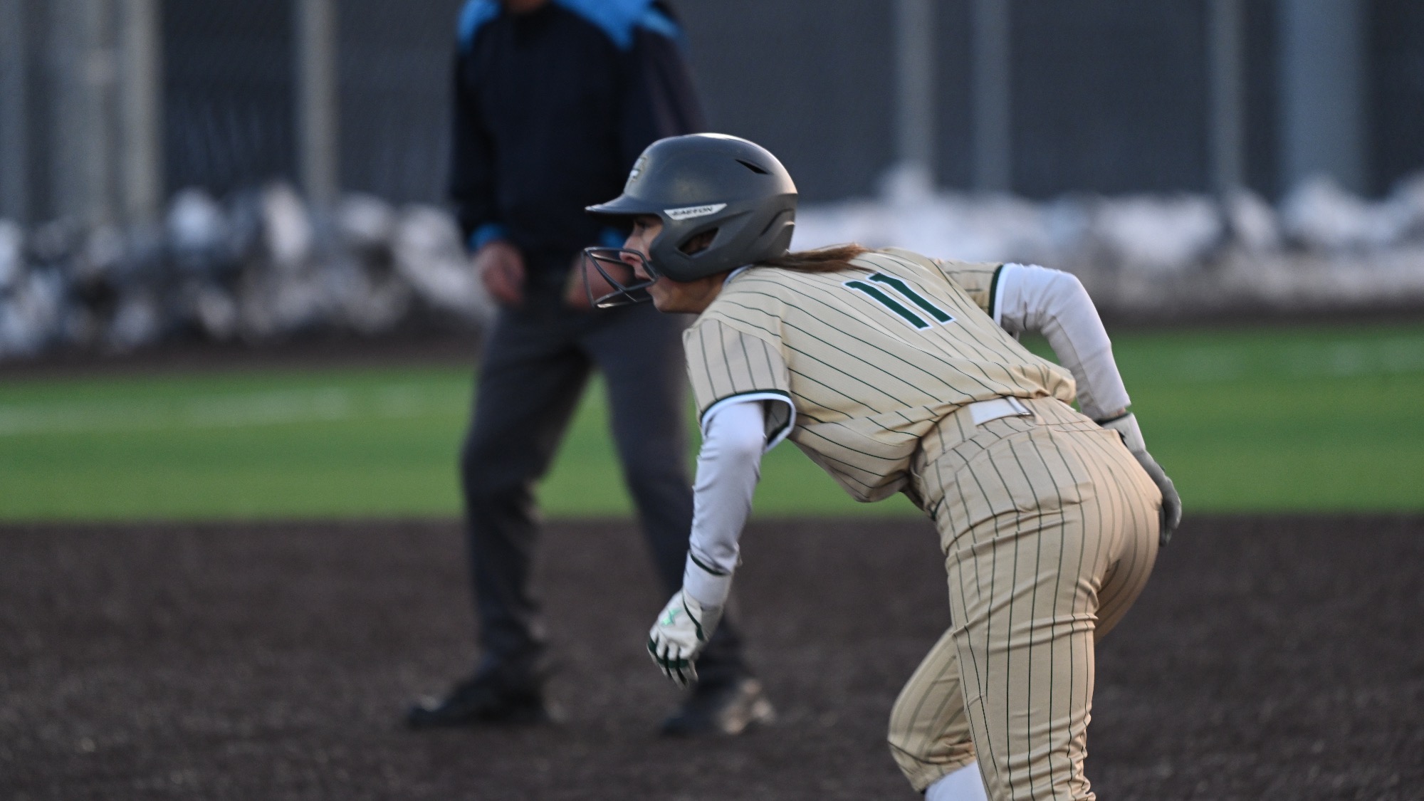 S&T softball player Kaylee LaChappell in gold stripes jersey getting ready to run on second base during a game.