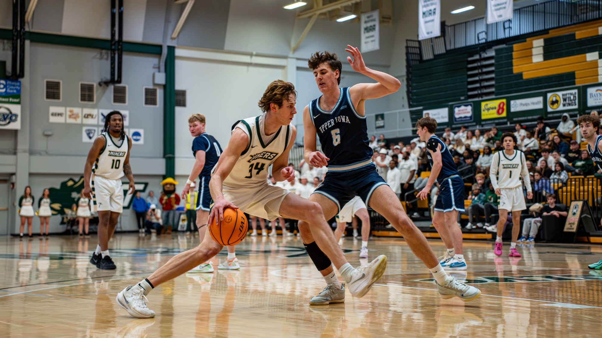 Missouri S&T men’s basketball player Andrew Young drives along the baseline toward the basket while being defended by an Upper Iowa player during a game at Gibson Arena.