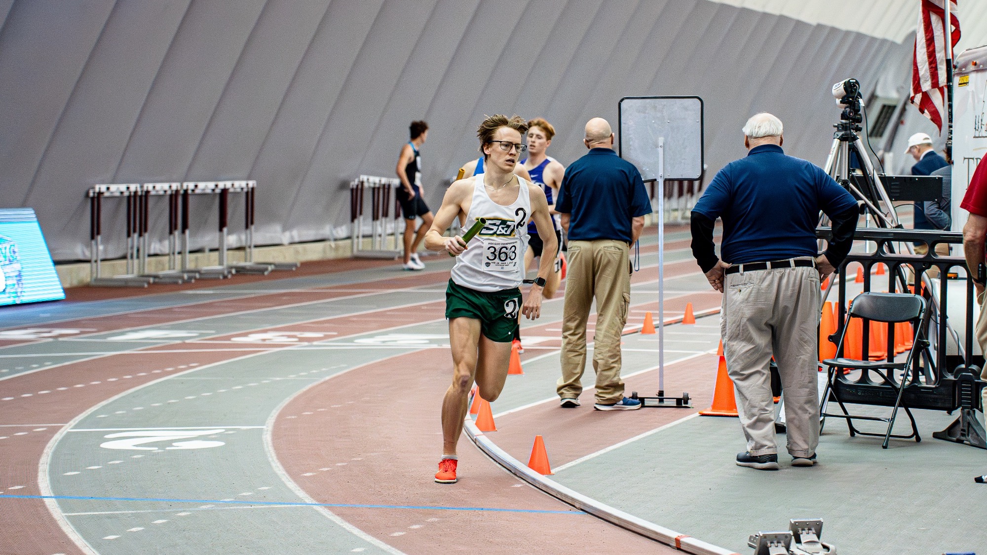 Missouri S&T distance runner Andrew Bacon running his part in the distance medley relay with runners behind him at the GLVC Indoor Track and Field Championships.