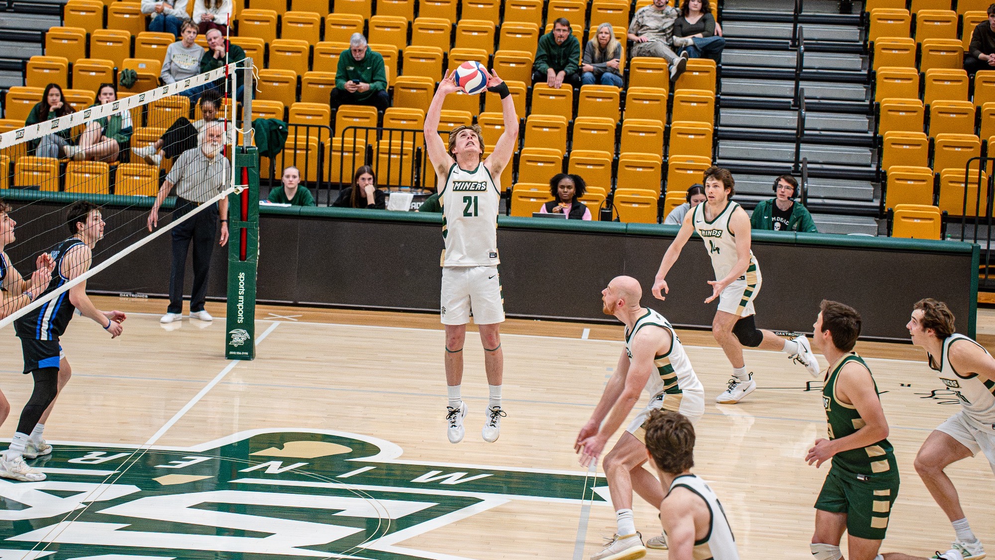 Missouri S&T setter Grant Edmonds jumps to set the ball near the net in Gibson Arena during a match against Rockhurst while teammates prepare for the attack.