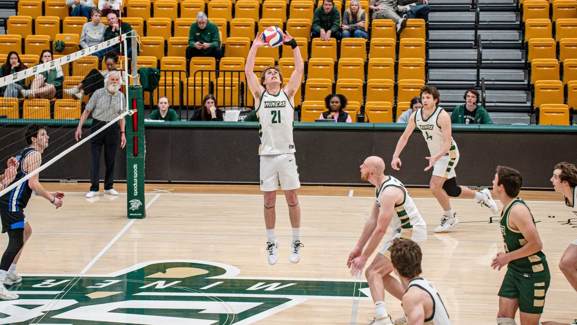 Missouri S&T setter Grant Edmonds jumps to set the ball near the net in Gibson Arena during a match against Rockhurst while teammates prepare for the attack.