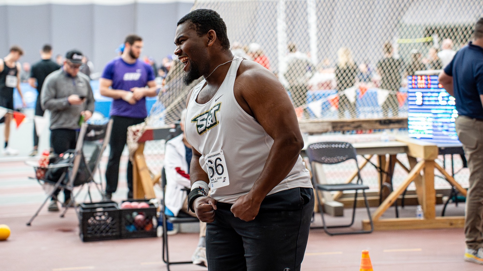 DJ Carter in white S&T uniform celebrating after competing in shot put at the GLVC Championships