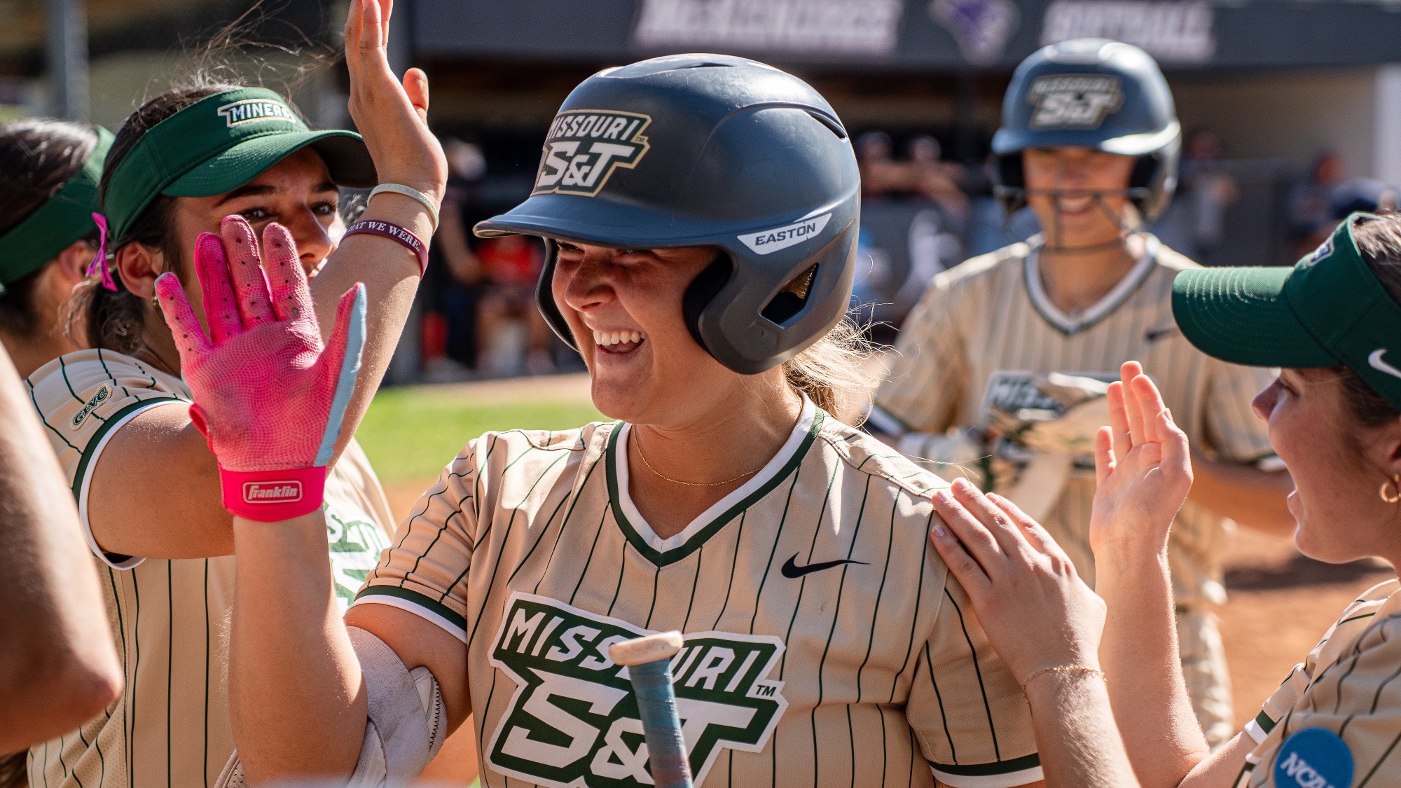 Missouri S&T softball outfielder Morgan Williams giving high fives after hitting home run at McKendree University.