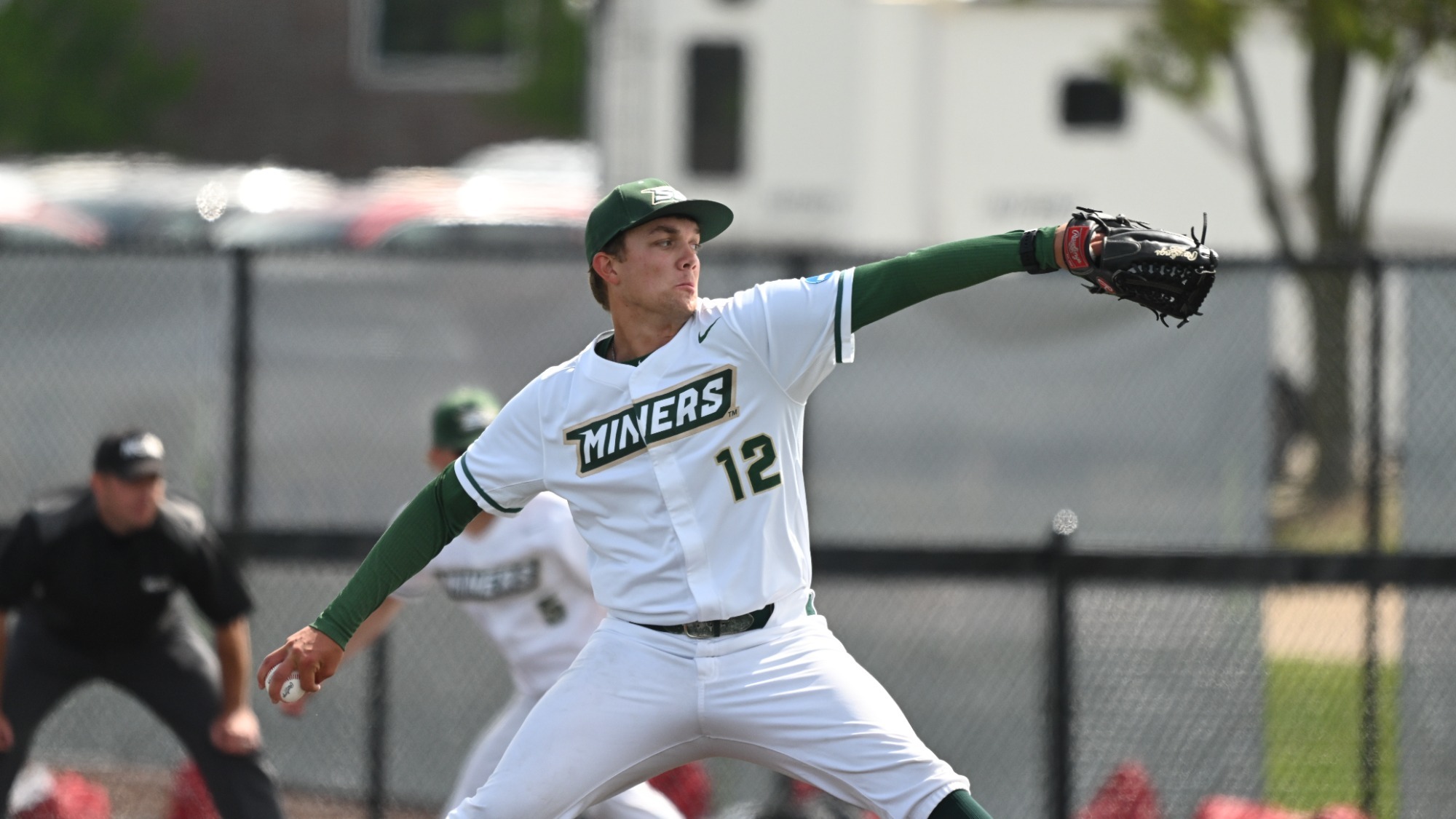 Zander Street of Missouri S&T winds to deliver a pitch during a game at Grand Valley State. He is wearing a white uniform