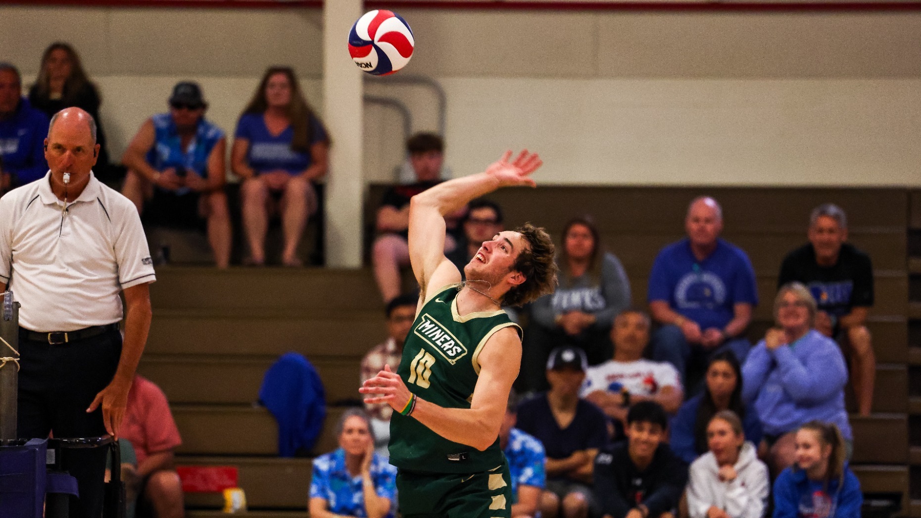 Missouri S&T Men's Volleyball outside hitter Nate Meyer photographed jumping and attacking during a match in Moloney Arena. He is looking up at the ball with his right arm back ready to swing.