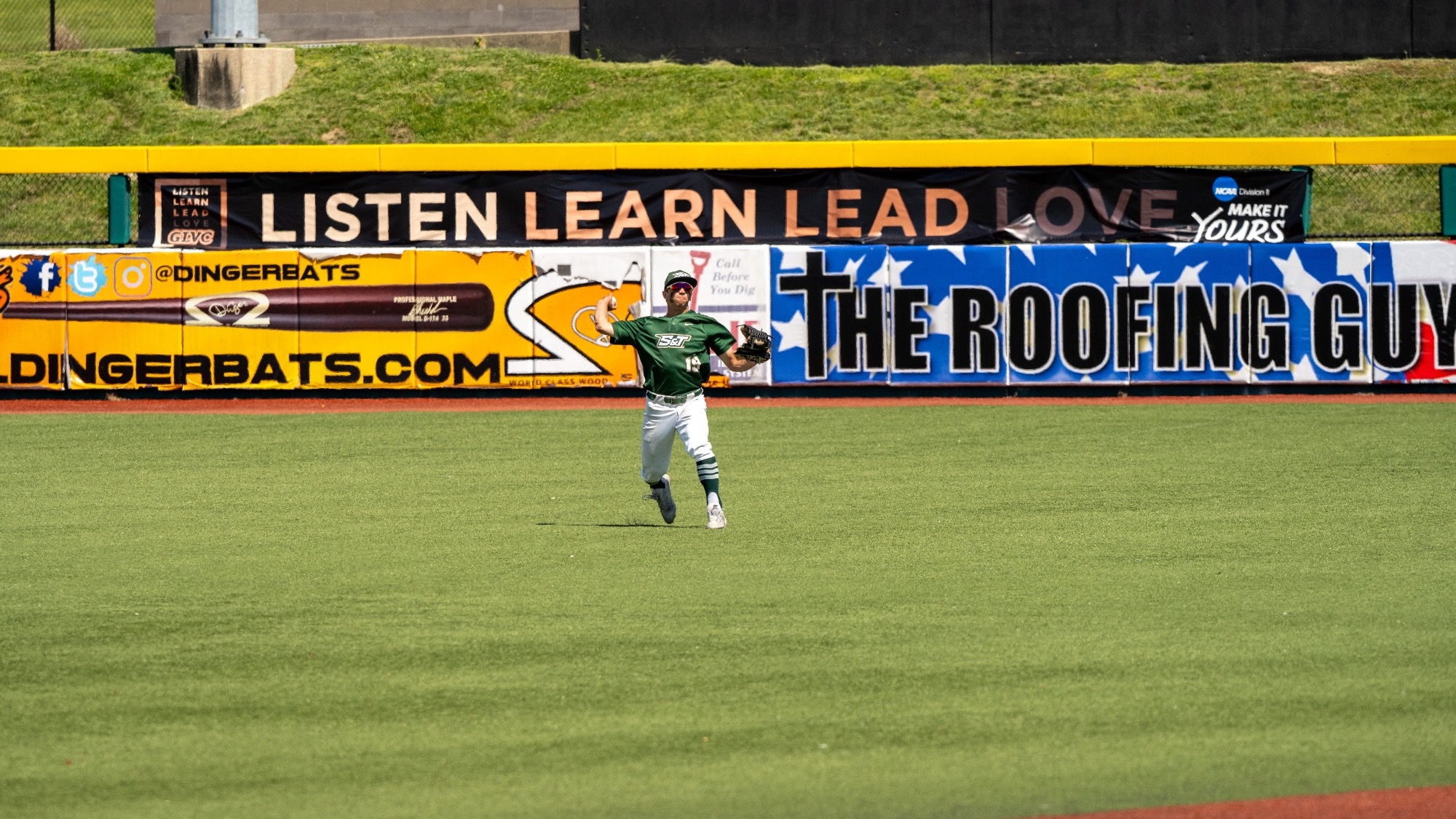 Drew Baugus of Missouri S&T Baseball is photographed mid-throw, throwing a baseball from the outfield during a game