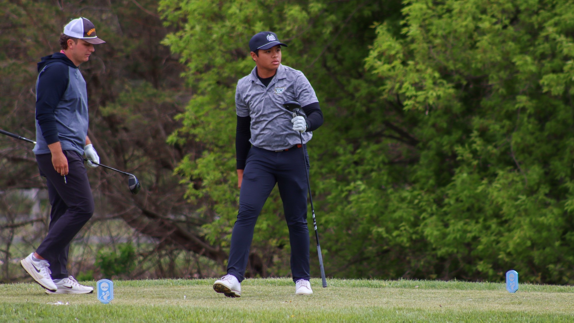 Rizq Adam Rohizam photographed looking down the fairway while standing on a tee box at Katke Golf Course. He holds his driver in his right hand