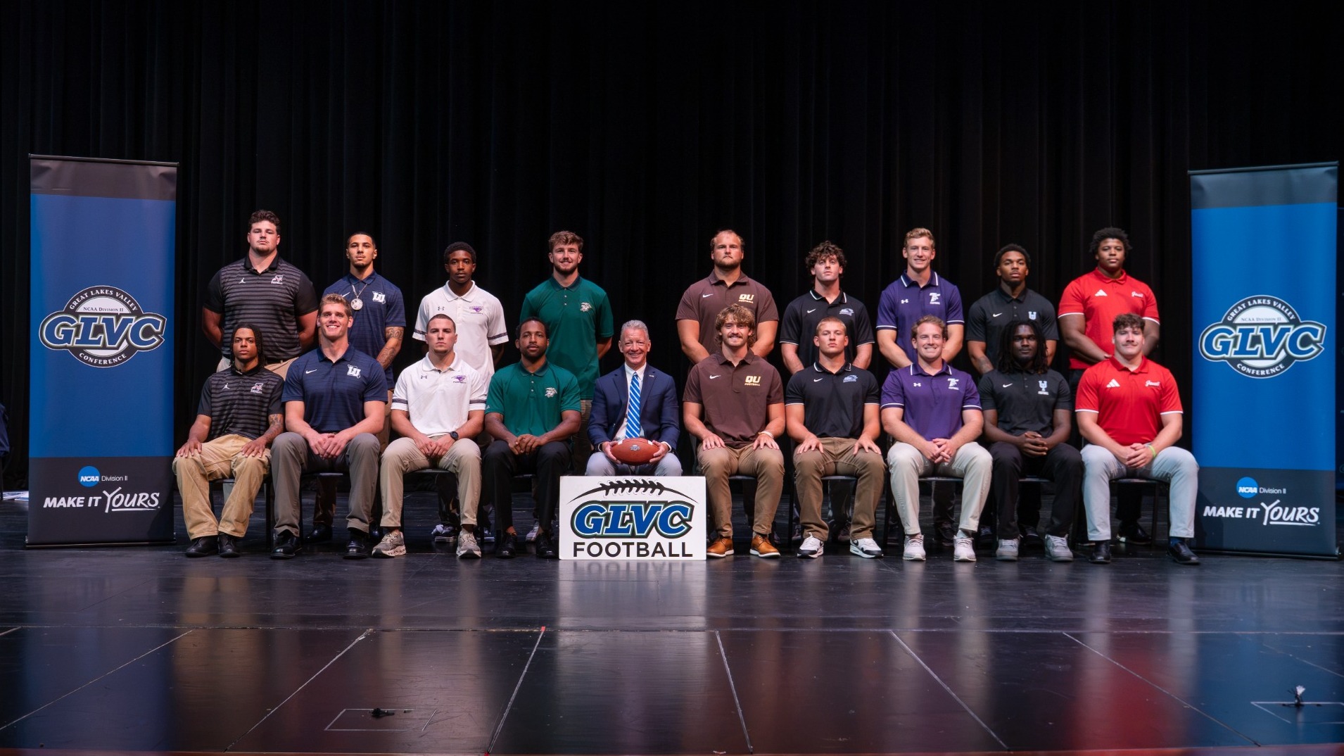 2026 GLVC Football Kickoff group photo with athletes from all GLVC football schools photographed while posed around GLVC Commissioner Jim Naumovich