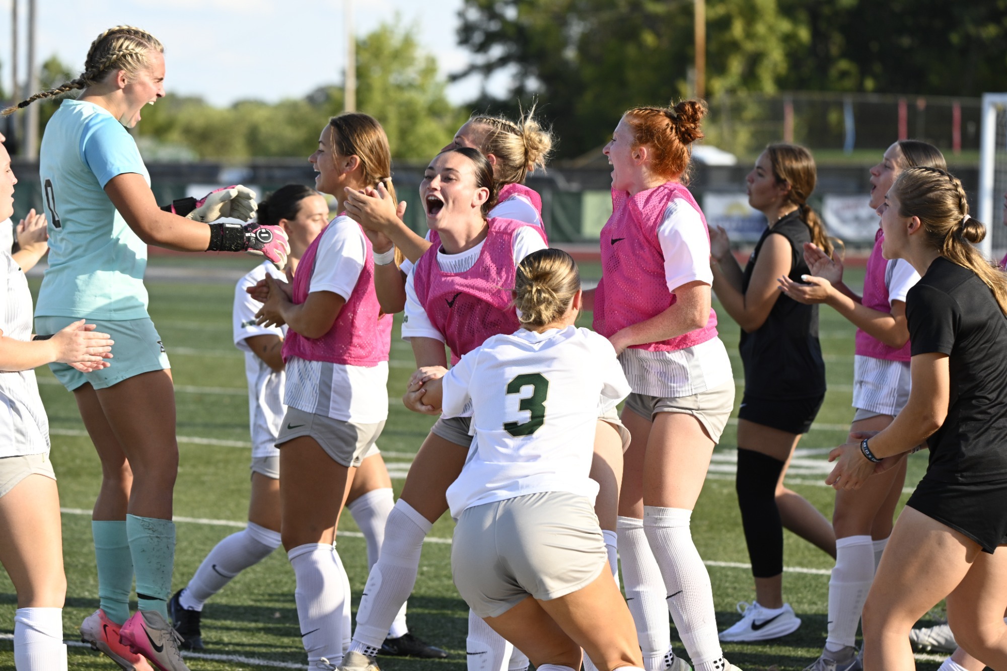 Missouri S&T women’s soccer players celebrate together on the field during a game.