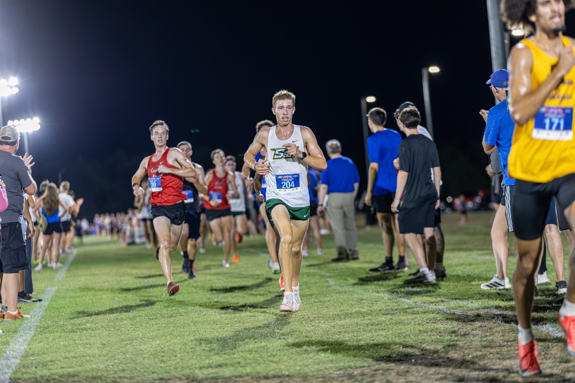 Noah Case running to the finish line in a white uniform