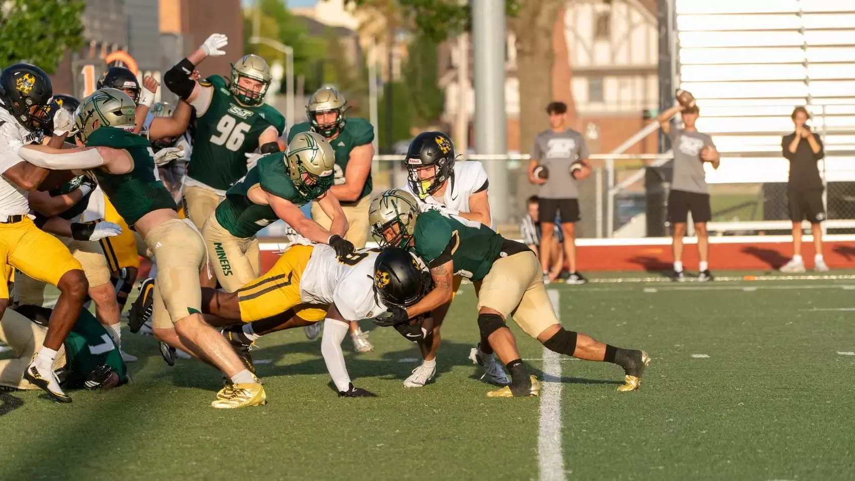 Devin Dunn and Reid Meekins of Missouri S&T football photographed tackling the Missouri Western running back during a game at Allgood-Bailey Stadium