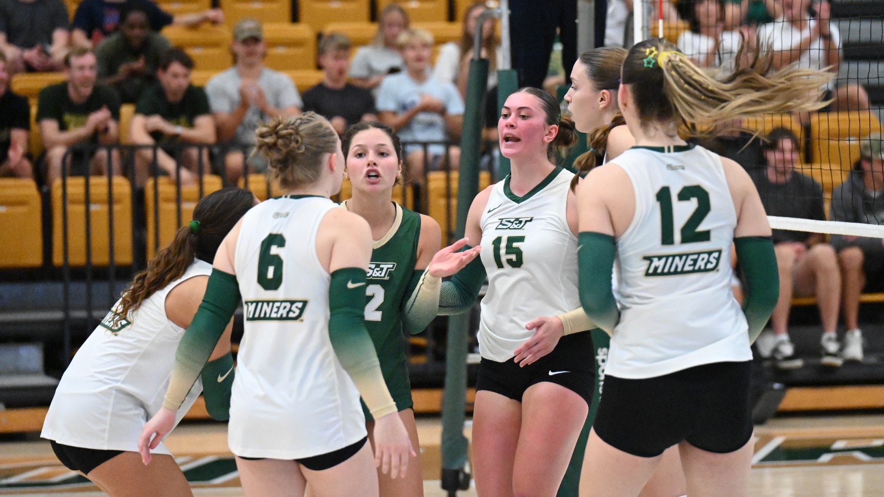 Women’s Volleyball Team huddling during a women’s volleyball match in Gibson Arena. 