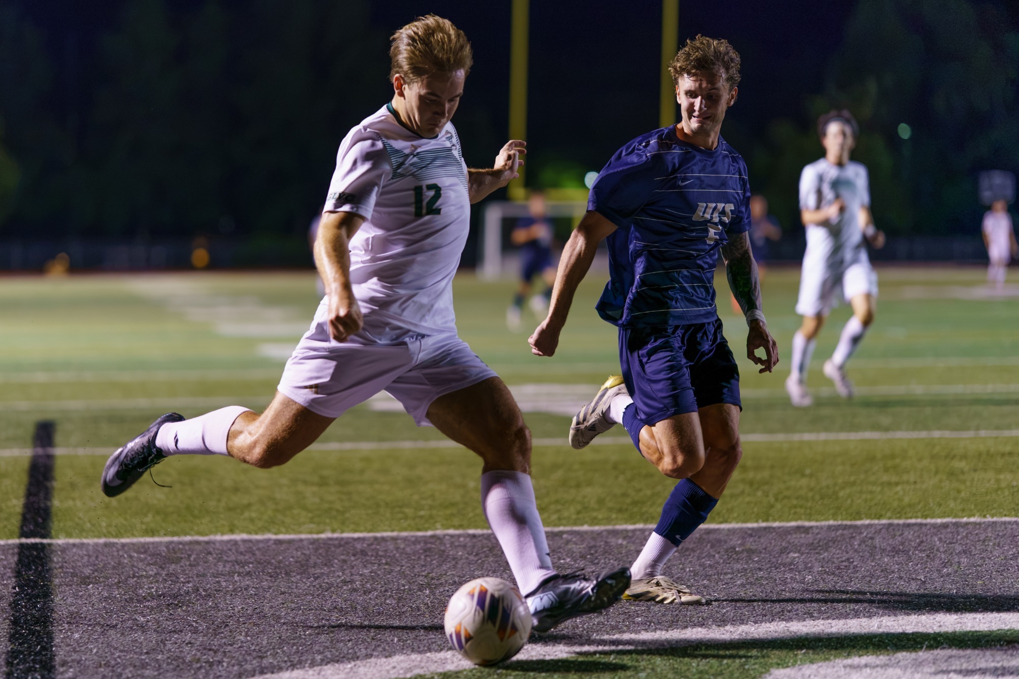 Kellen Douglas attacking the ball mid kick for the Miners. In a white jersey and white shorts