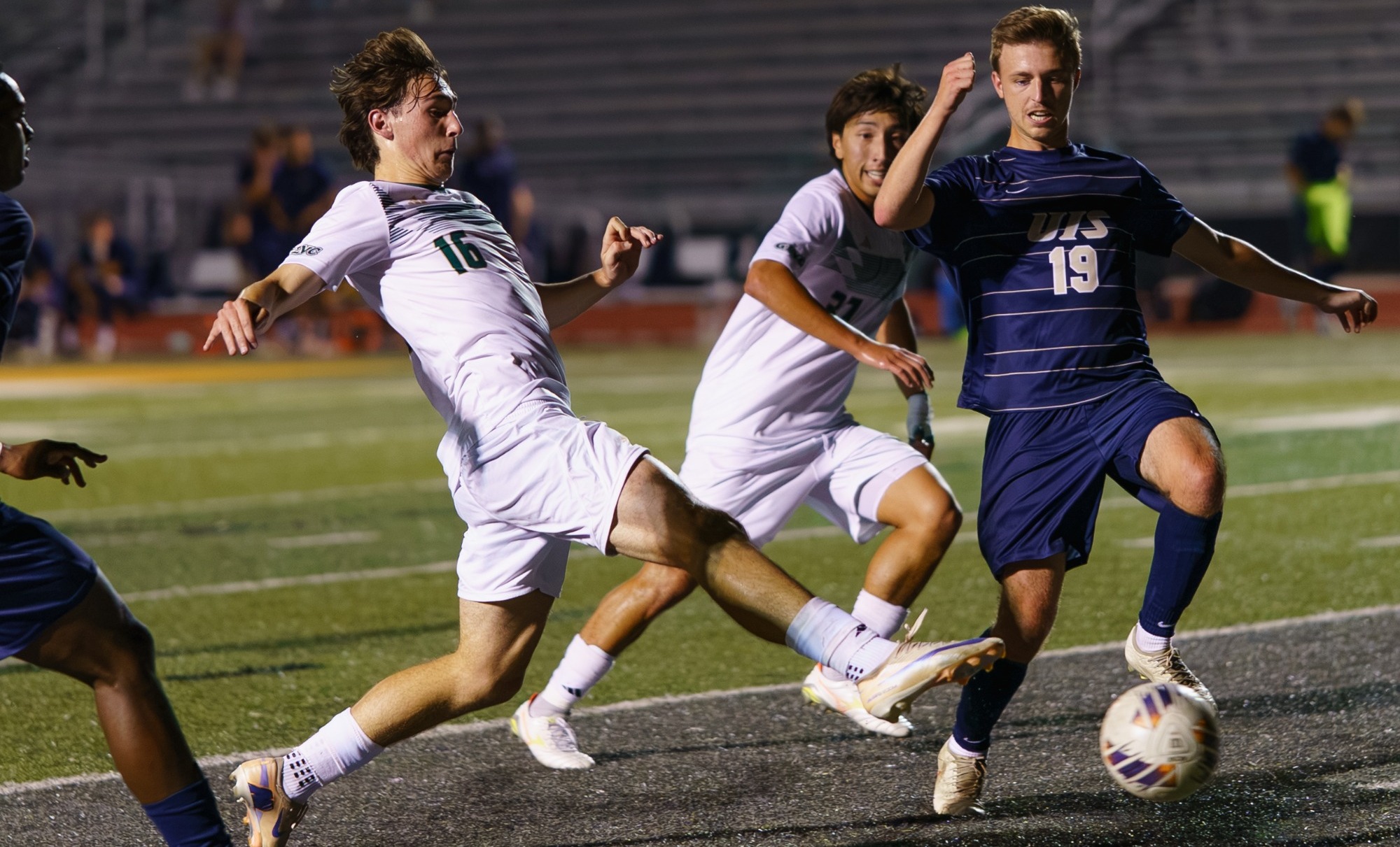 Ian Conner for Missouri S&T in a white jersey and white shorts stretching his leg out for a soccer ball 