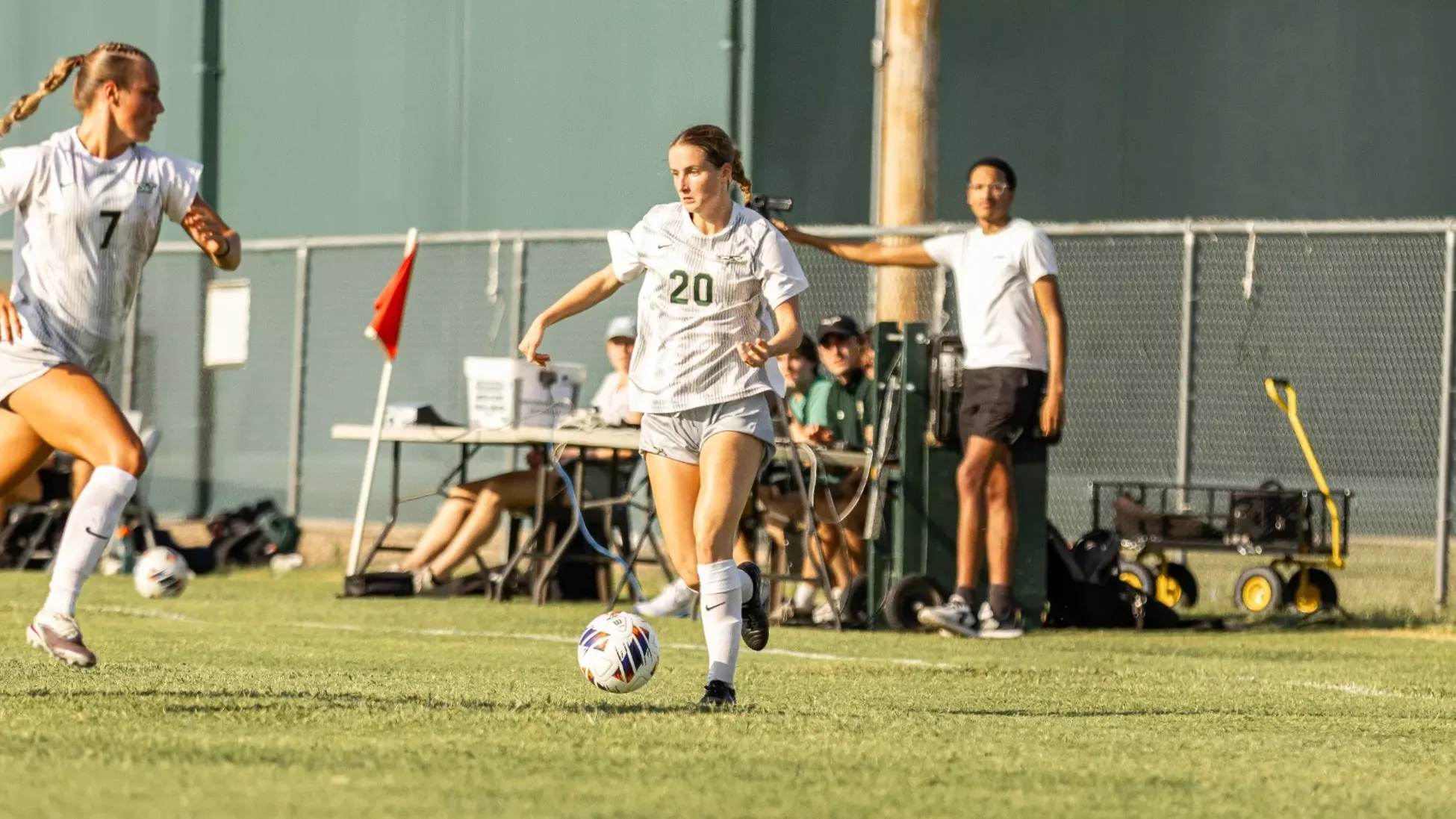 Carlye Bennett dribbling the ball in a white uniform with white shorts