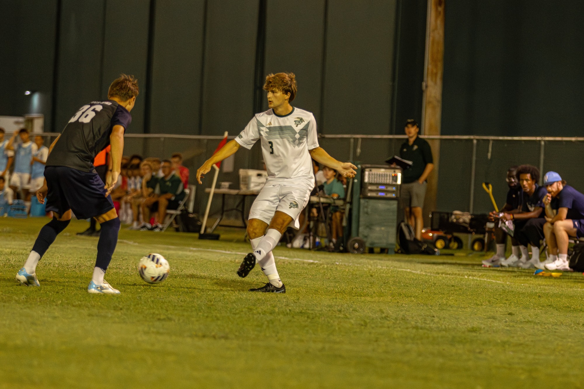 Joseph Sommer attacking the soccer ball wearing a white jersey and white shorts 