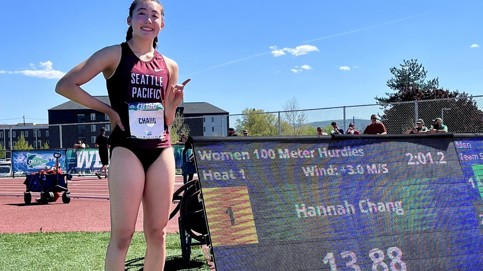 Hannah Chang by the scoreboard after winning the 100 hurdles at GNAC.