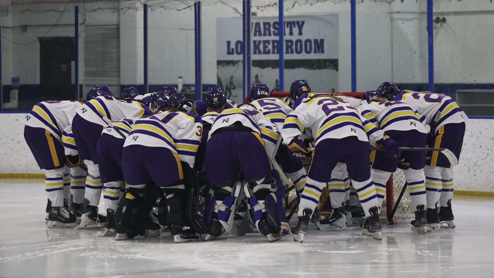 hockey team huddle around net