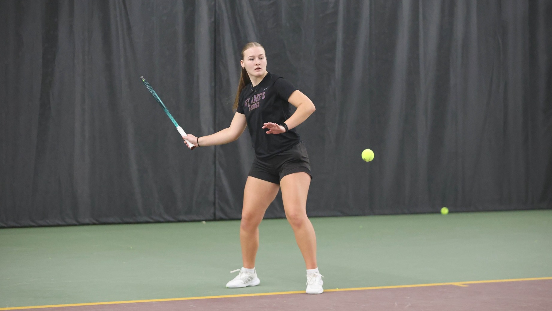 Ashley King hitting tennis ball at Baseline Tennis Center