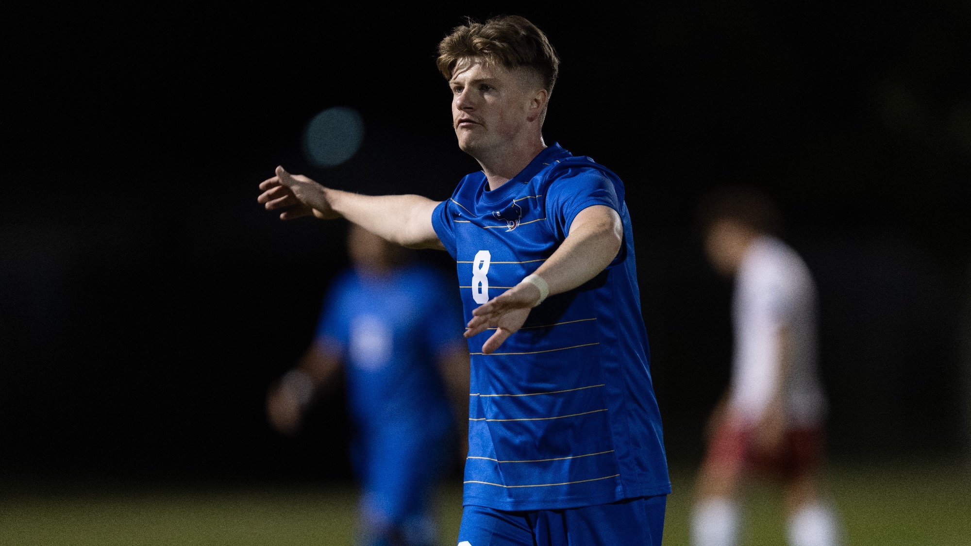 Shea Scally reaches out his right arm to high five a teammate.