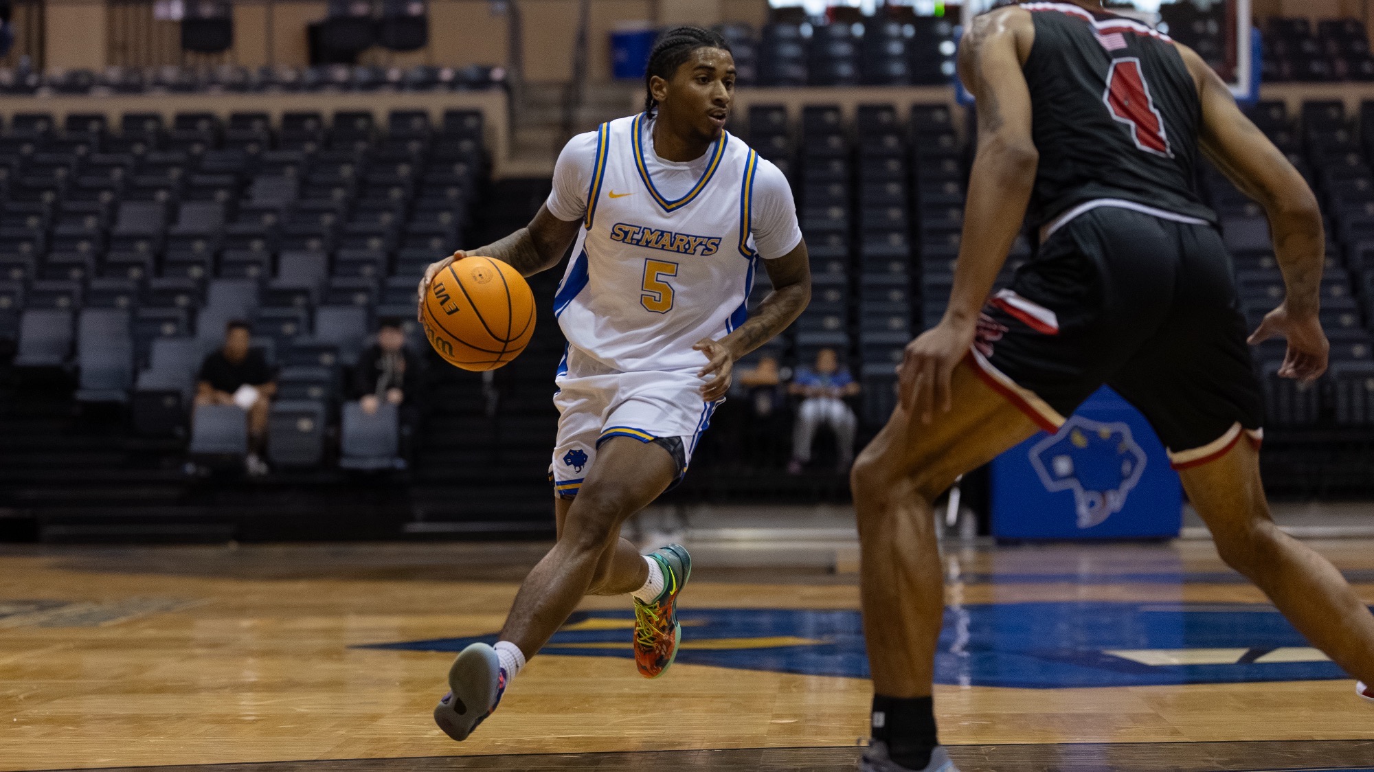 Damani Claxton drives down the court, dribbling the basketball.