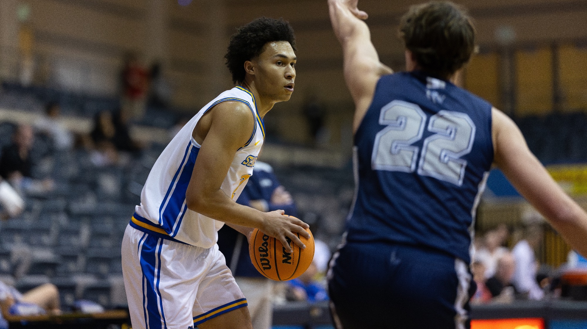 Eddie McPhee holds the ball in both hands as a defender closes in on him.