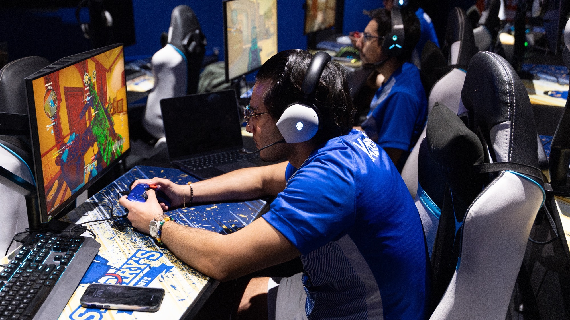 The Call of Duty team sits at three straight computer monitors with controllers in their hands.