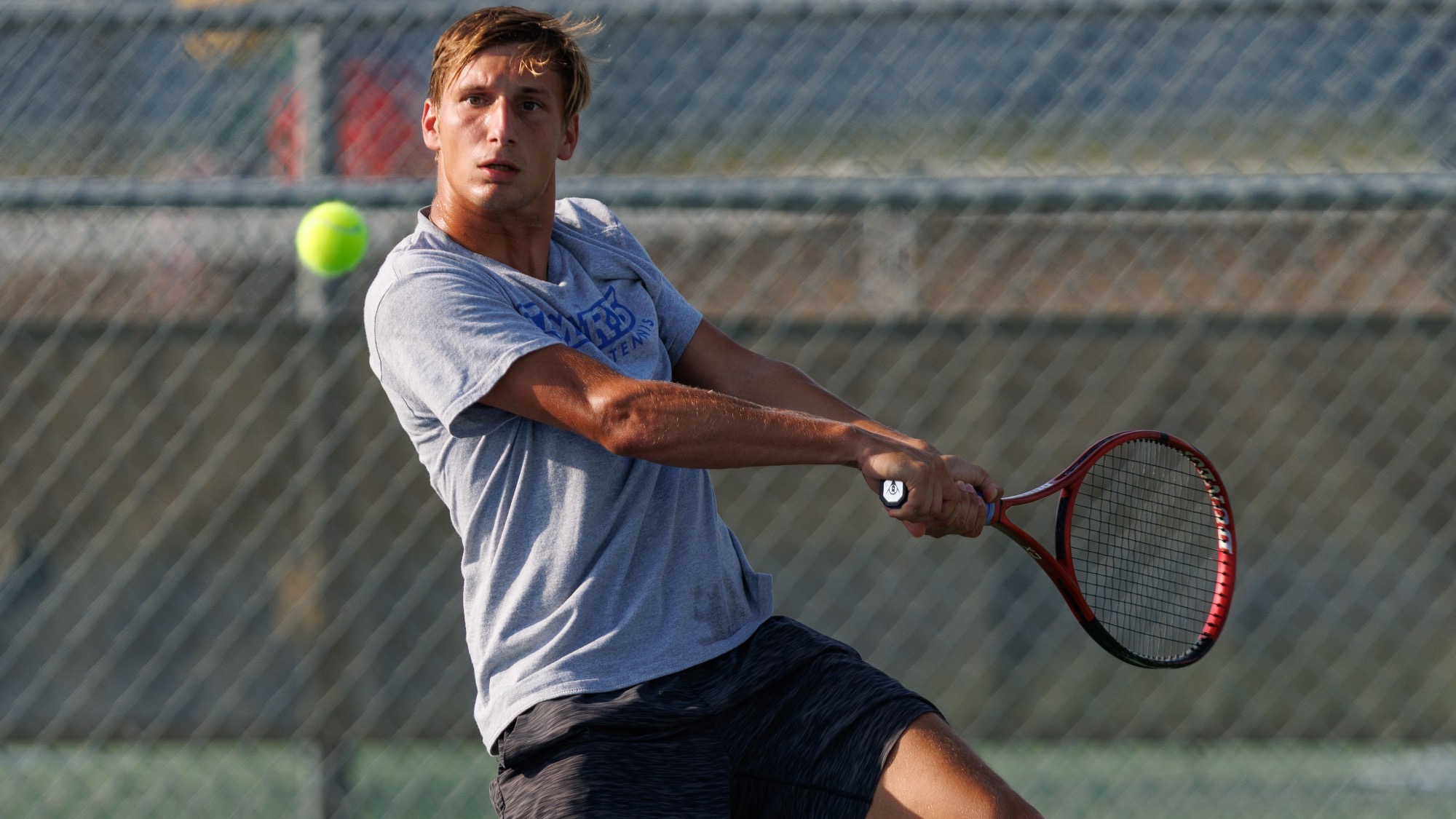 Bernhard Hauer hits a two-handed backhand at the Brother Al Invitational