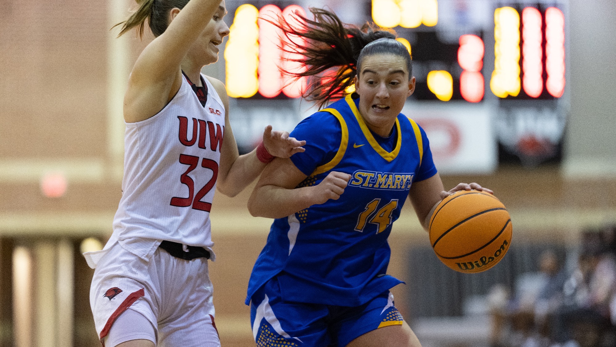 Aina Maynou drives toward the basket with a defender on her hip