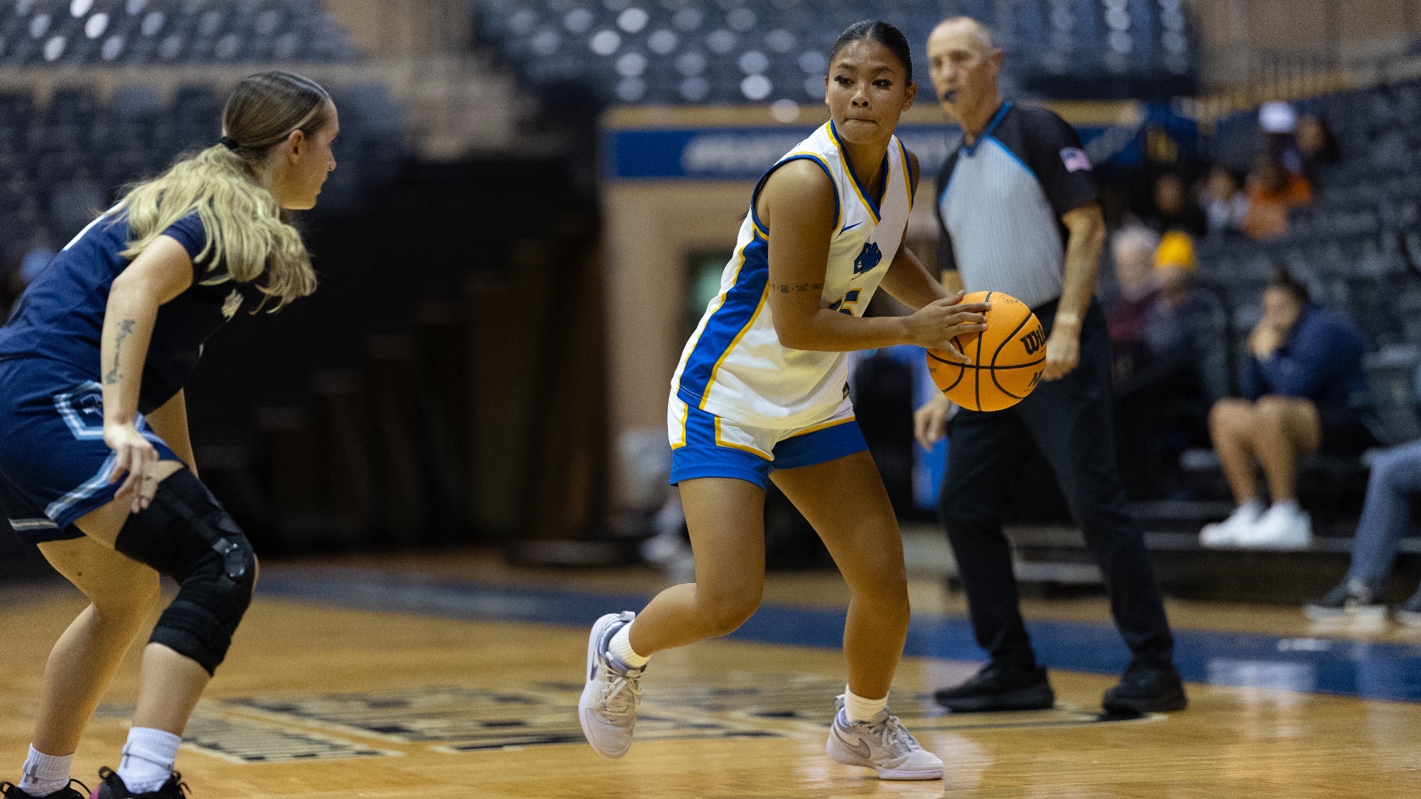Allie Garcia holds the ball at her waist, looking to pass the ball into the paint to a teammate.