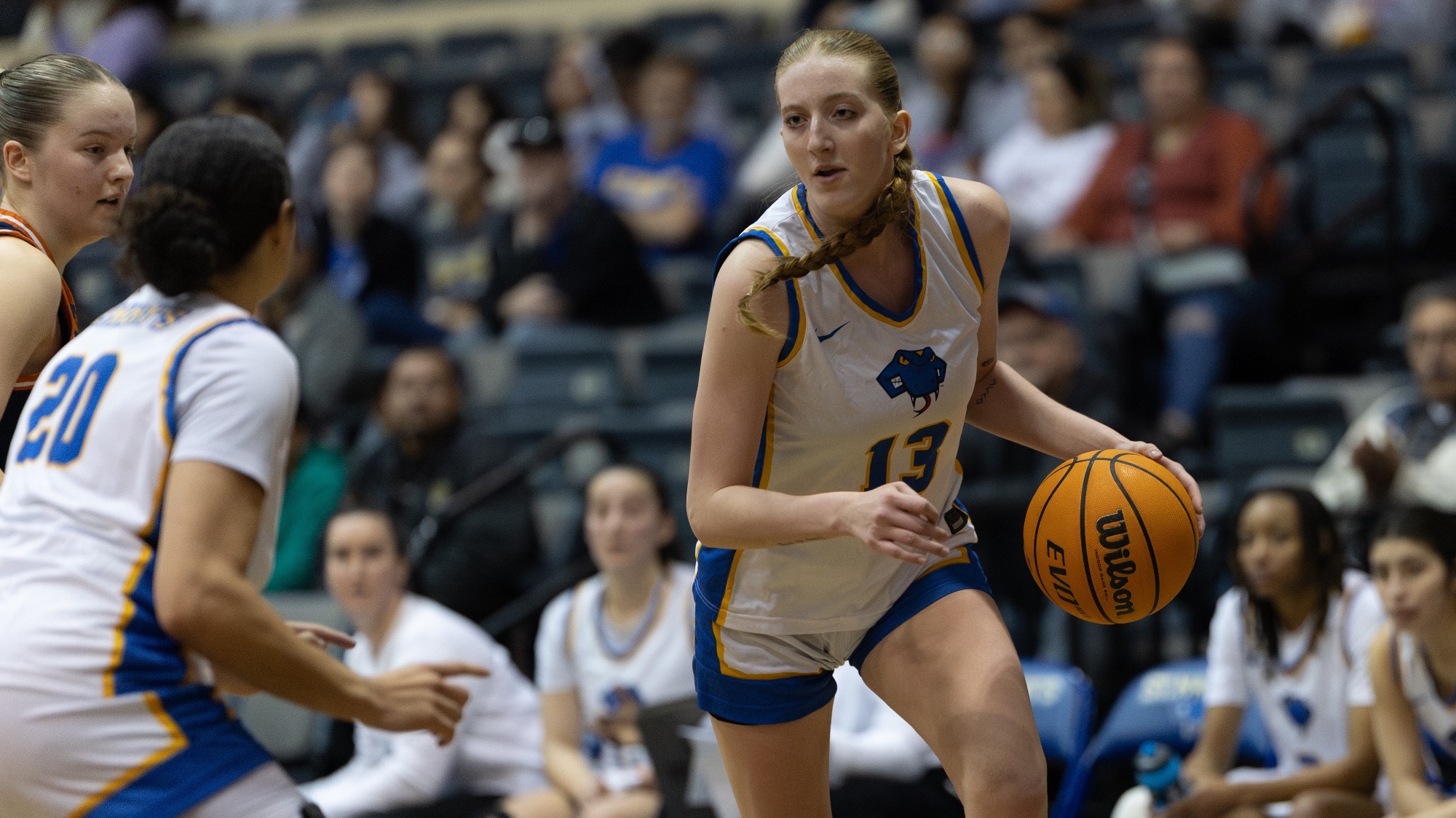 Raynne Malik drives to the basket with the ball in her left hand.