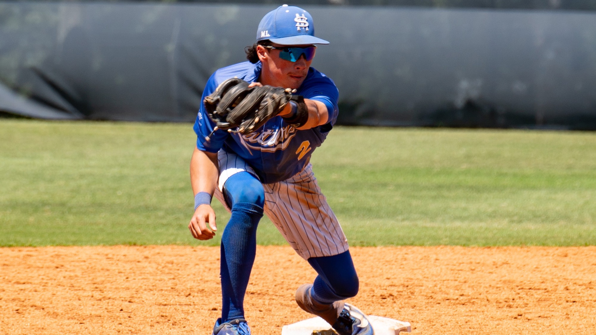 Raithen Malone catches the ball across his body as he stands on second base.
