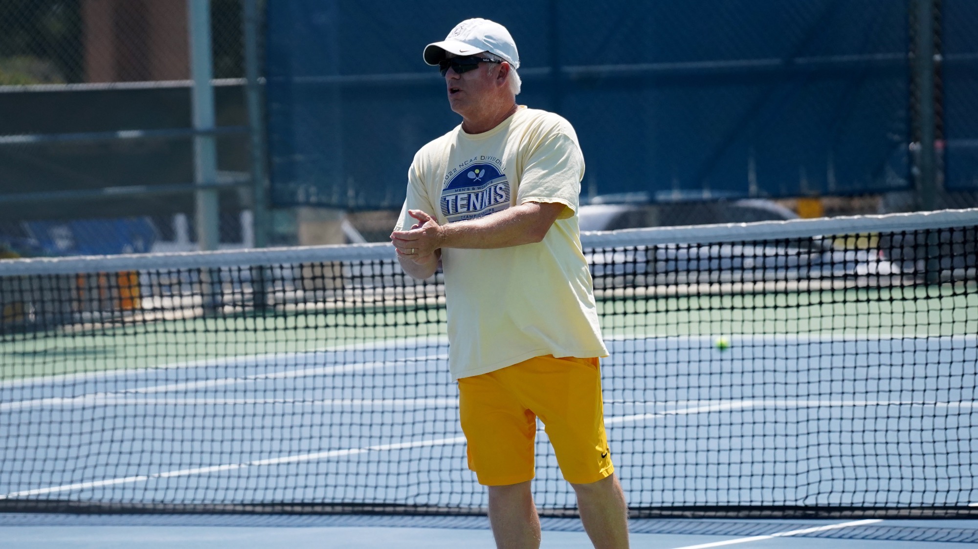 Bill Macom clasps his hands in front of him while standing in front of the net.