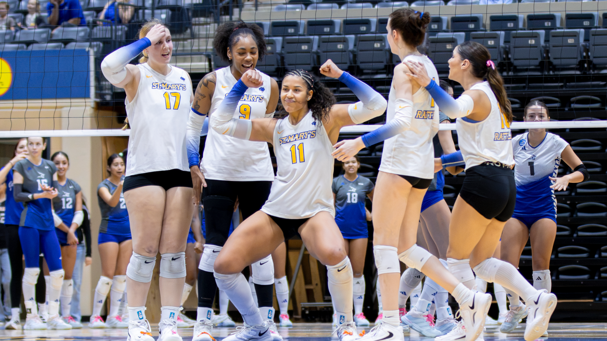 Laurene Robinson celebrates a block with her teammates surrounding her.