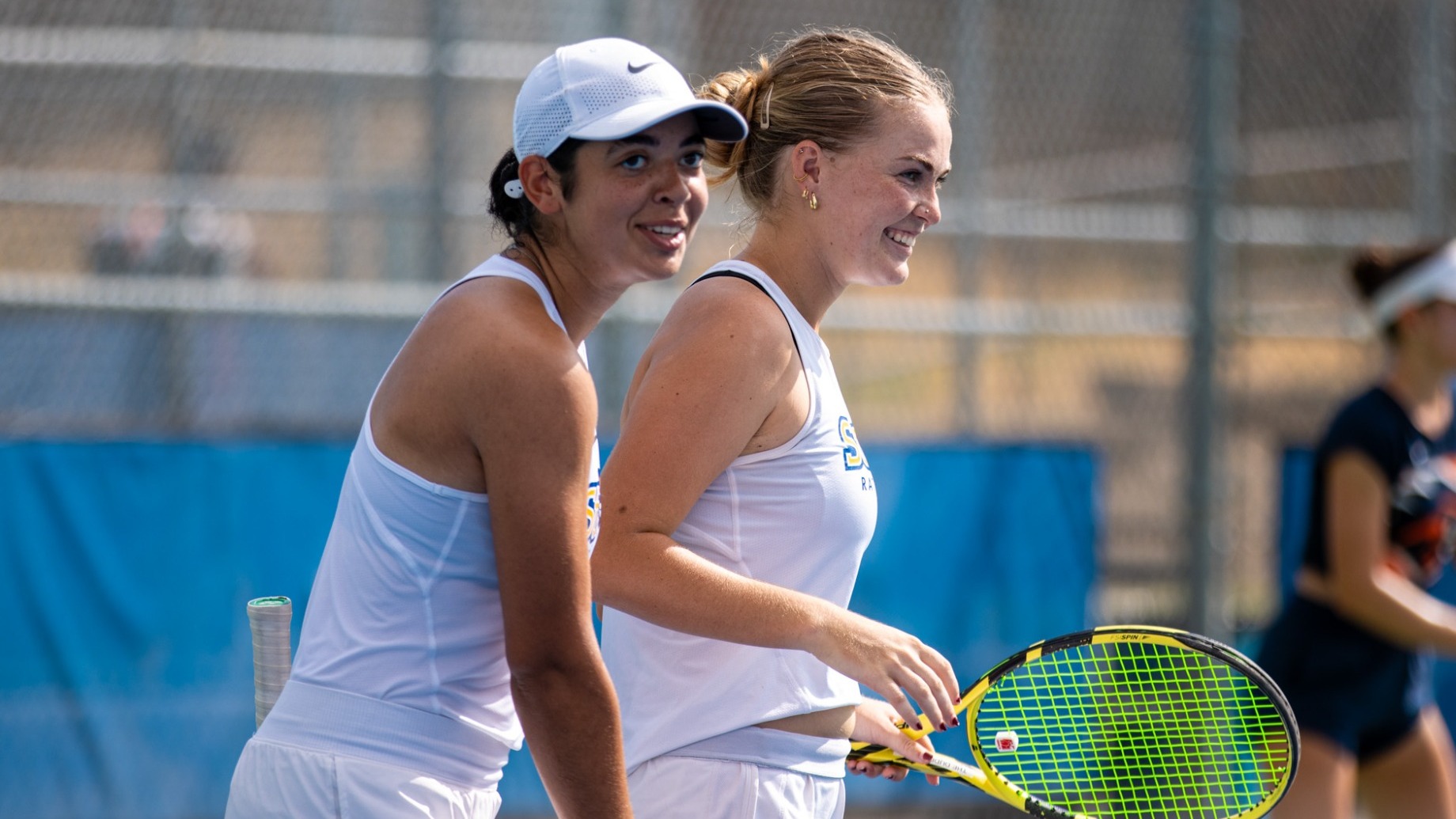 Ilona Hernandez Sanchez and Breeze Simon smile on the sidelines