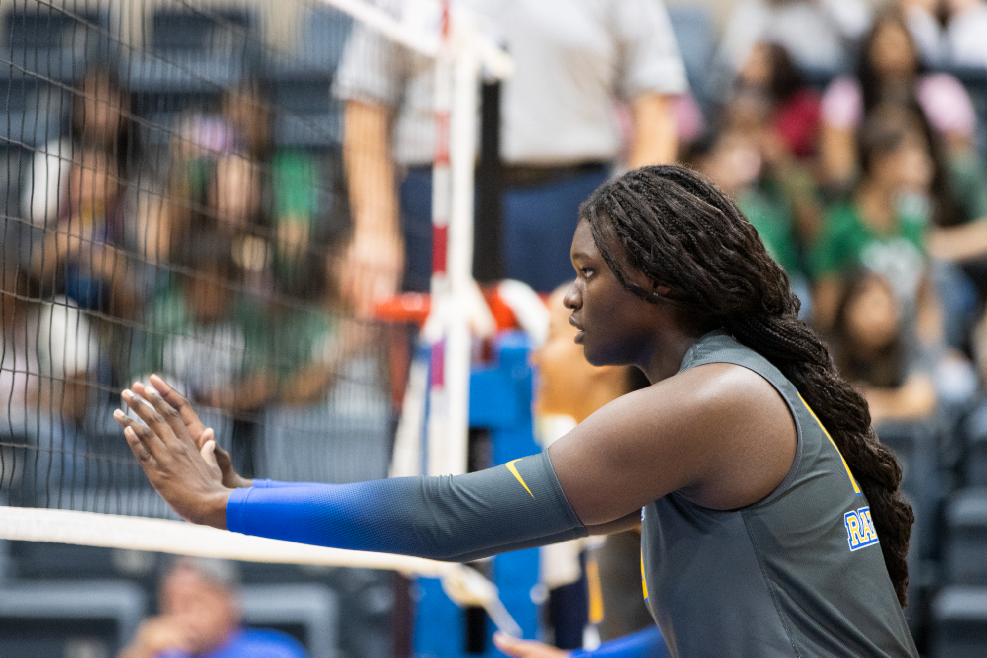 Madyson Carr stands at the net with her hands reached out in front of her, waiting on the play to begin.