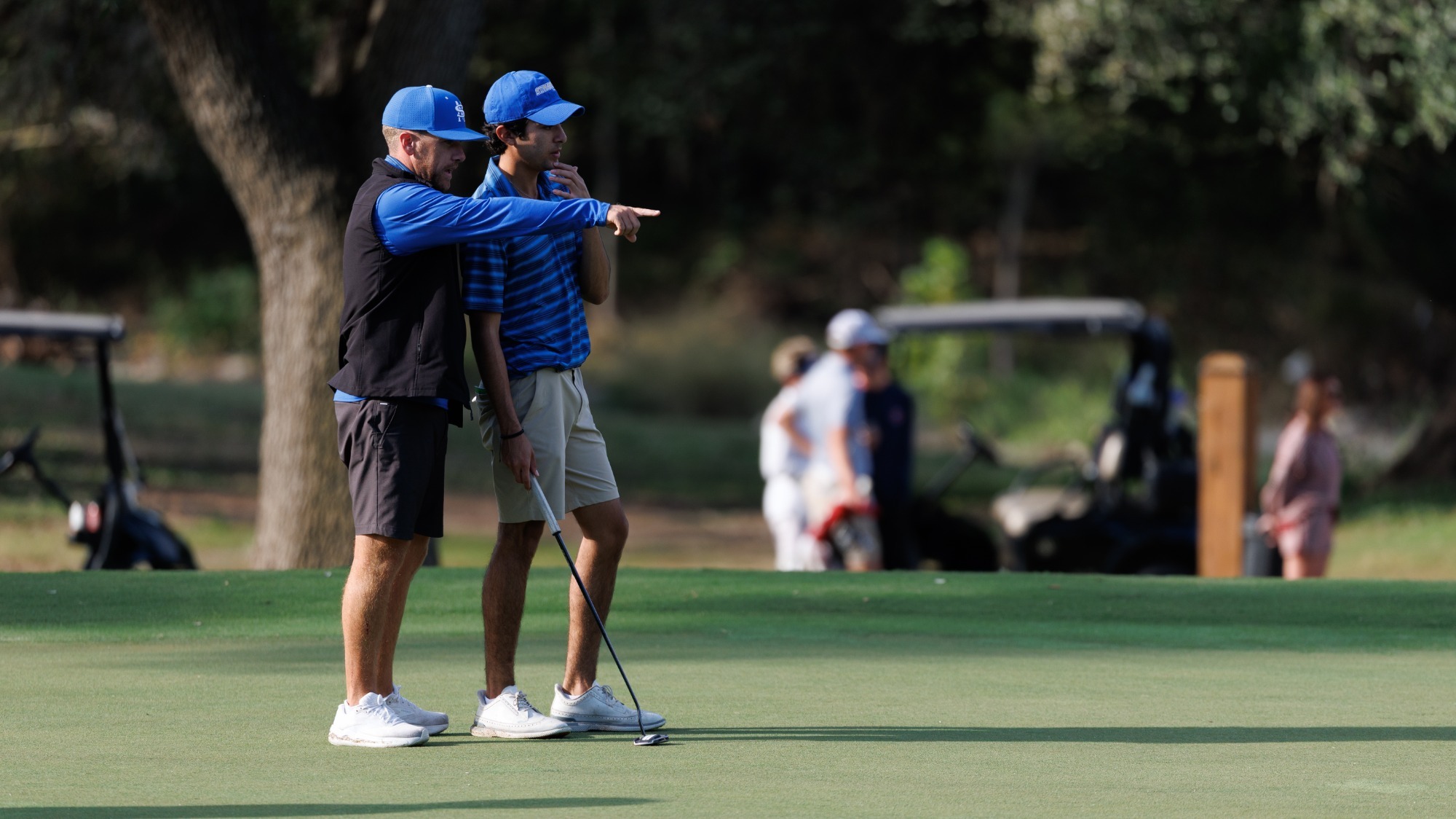 Head Coach Connor McCarthy points out the lie to freshman Diego Serrano at the Dominion Country Club.