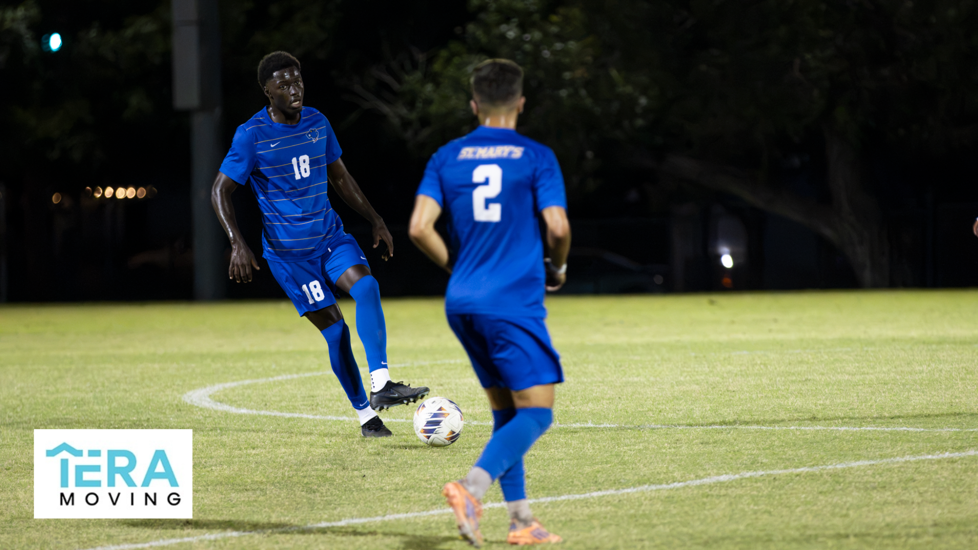 Pape Gueye stops the momentum of the ball rolling with his foot as he changes direction to pass to Filipe Bastos. The Tera Moving logo is in the bottom left.