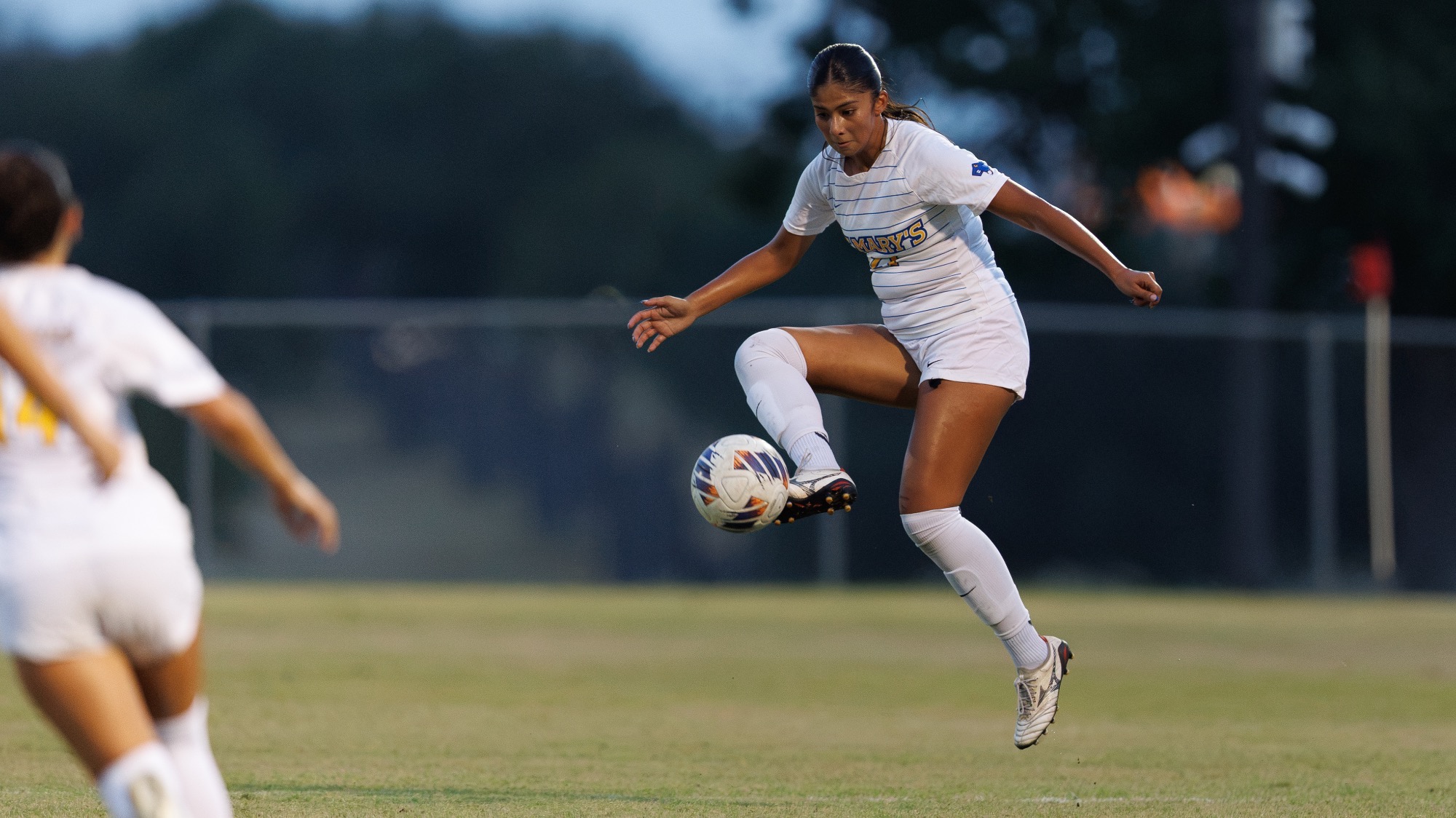 Marily Garza Contreras leaps in the air to kick the soccer ball.