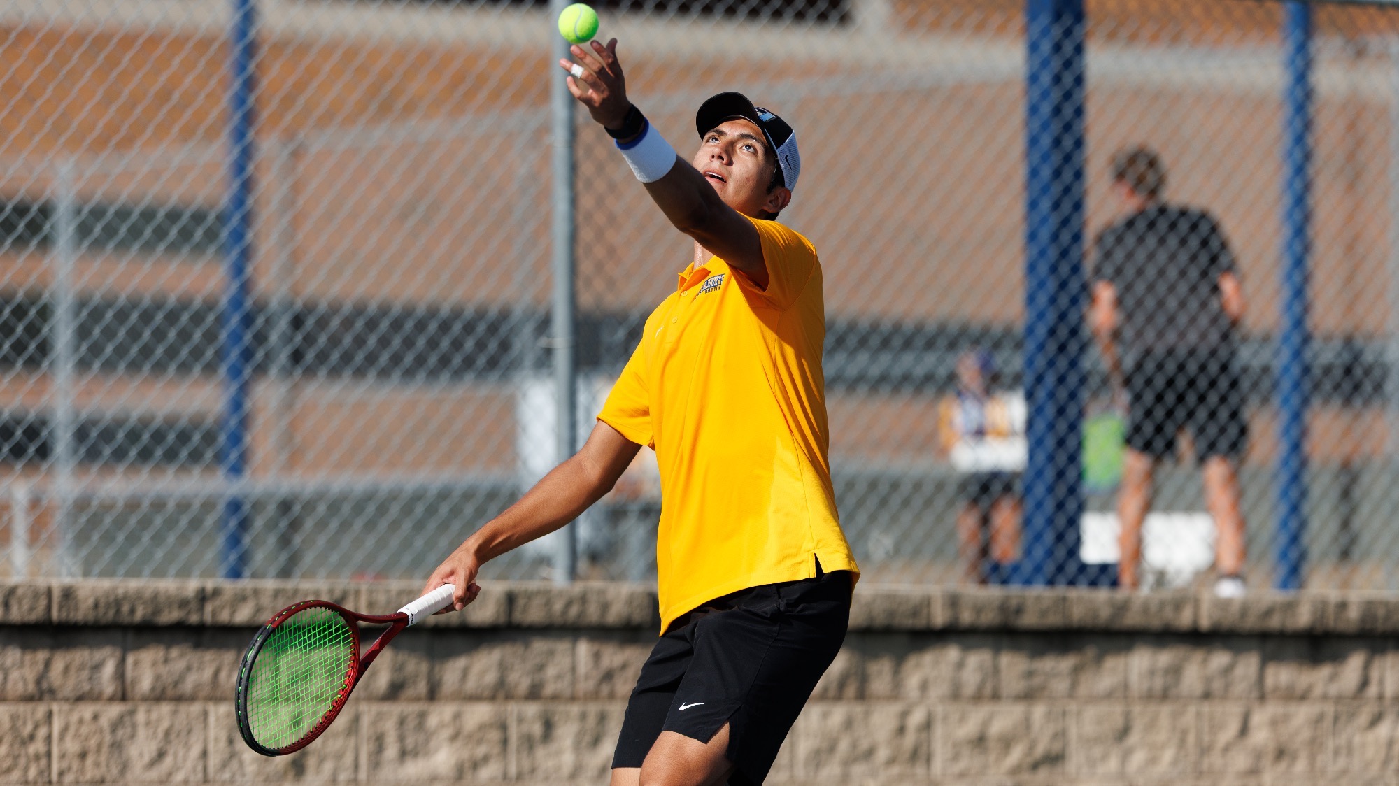 Diego Alvarez tosses the ball with his left hand to begin his serving motion.