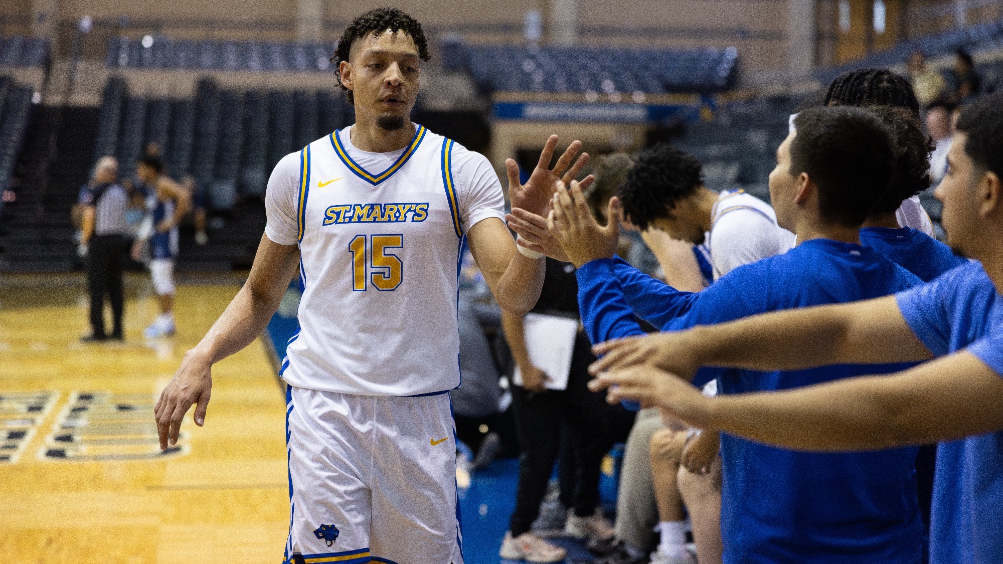Nacho Camacho gives high fives to his teammates on the bench.