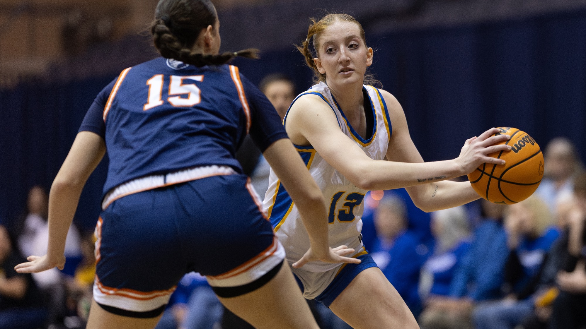 Raynne Malik holds the ball off to the left side of her waist as a defender closes in.