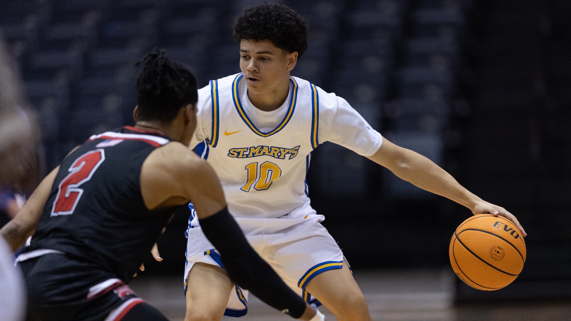 Raken Vargas dribbles the ball with his left hand as he looks right for an open teammate.