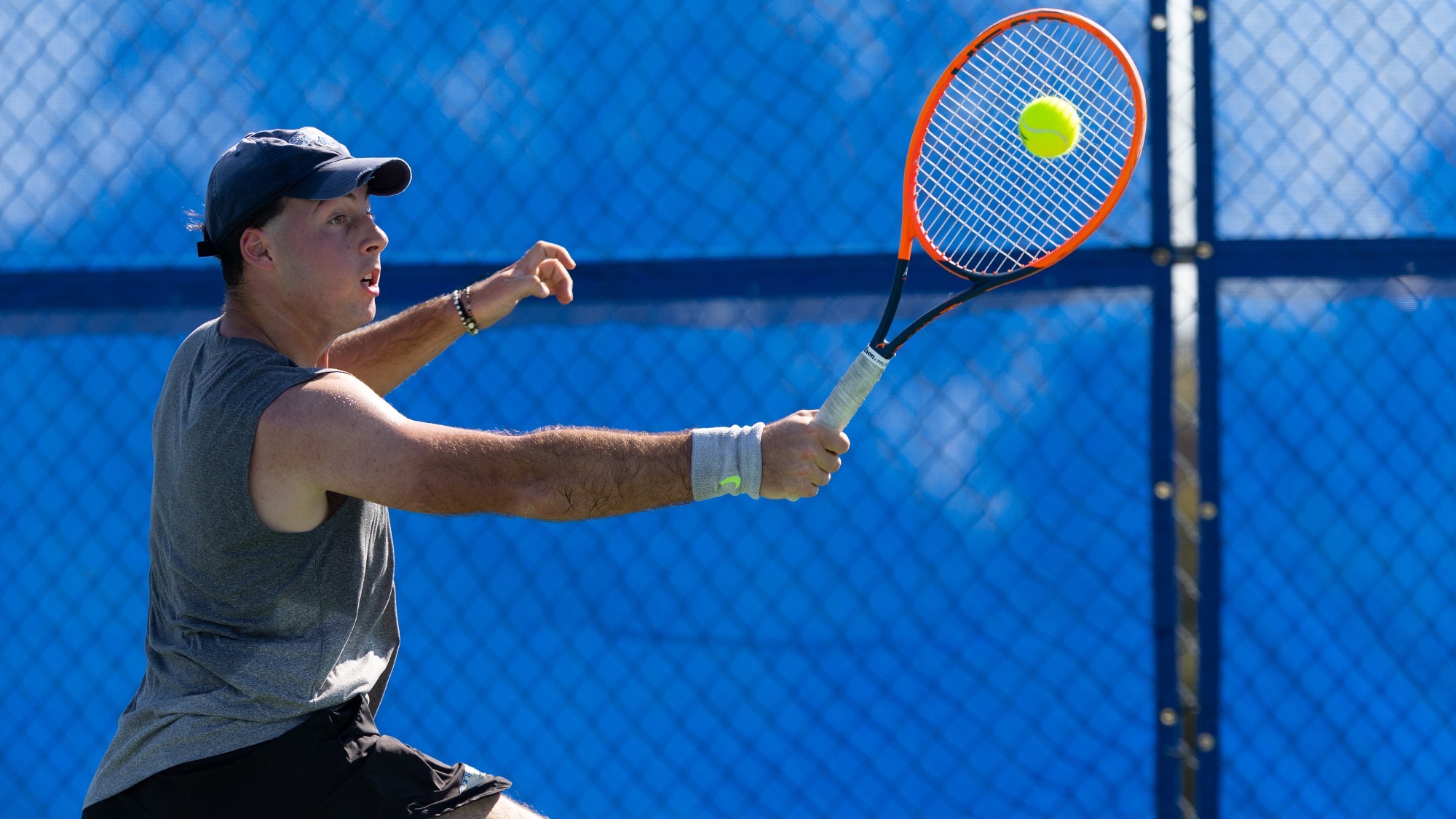 Leonardo Fabbri hits a back hand with his back to the court.