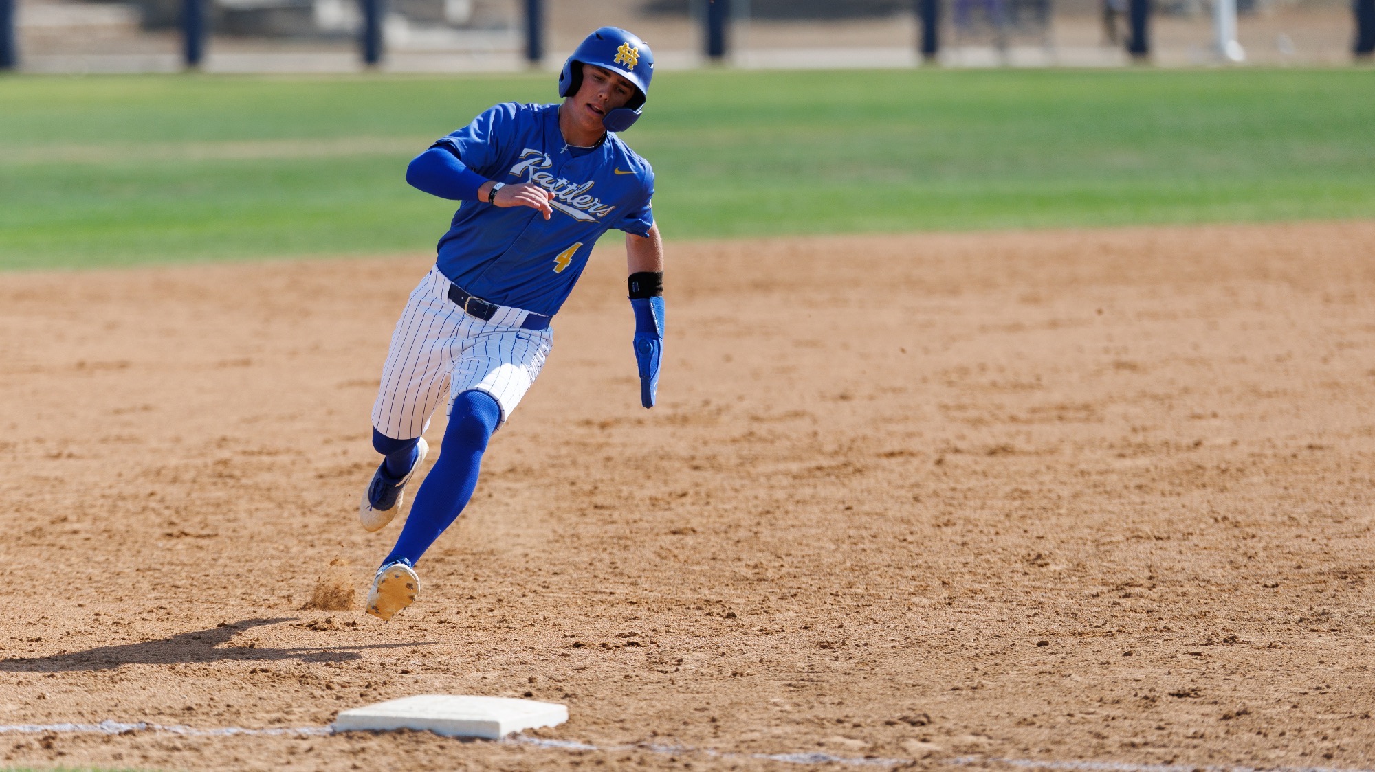 Blake Allen runs toward the third base bag, rounding like he'll head for home.