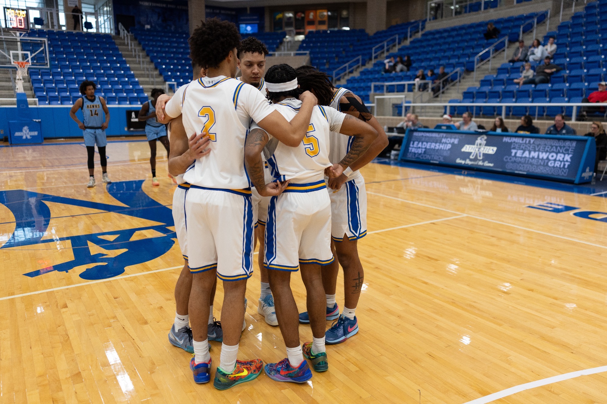 The men's basketball starters huddle up before the start of the game at Northside Gym against Fort Lewis.