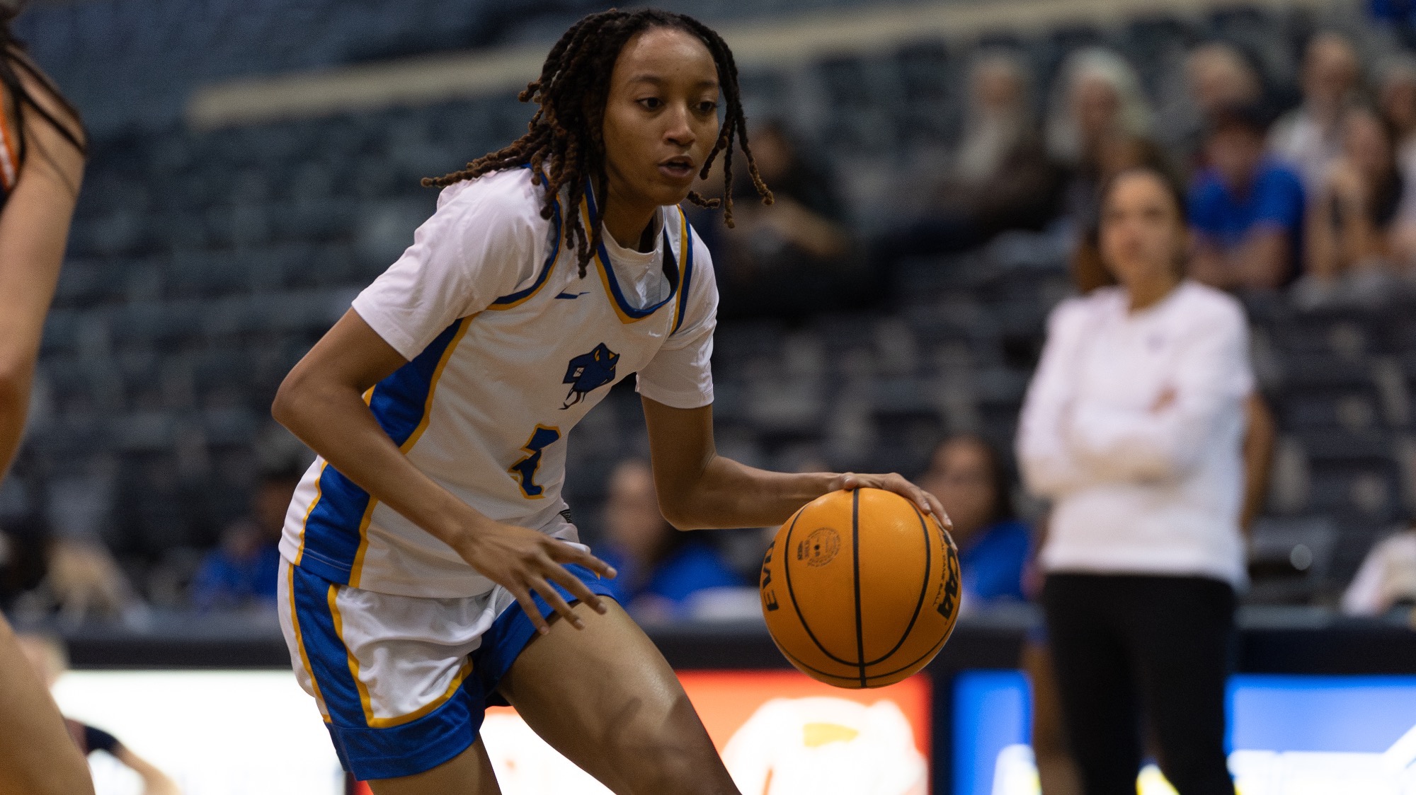 Imani Ivery drives the lane dribbling the ball with her left hand.